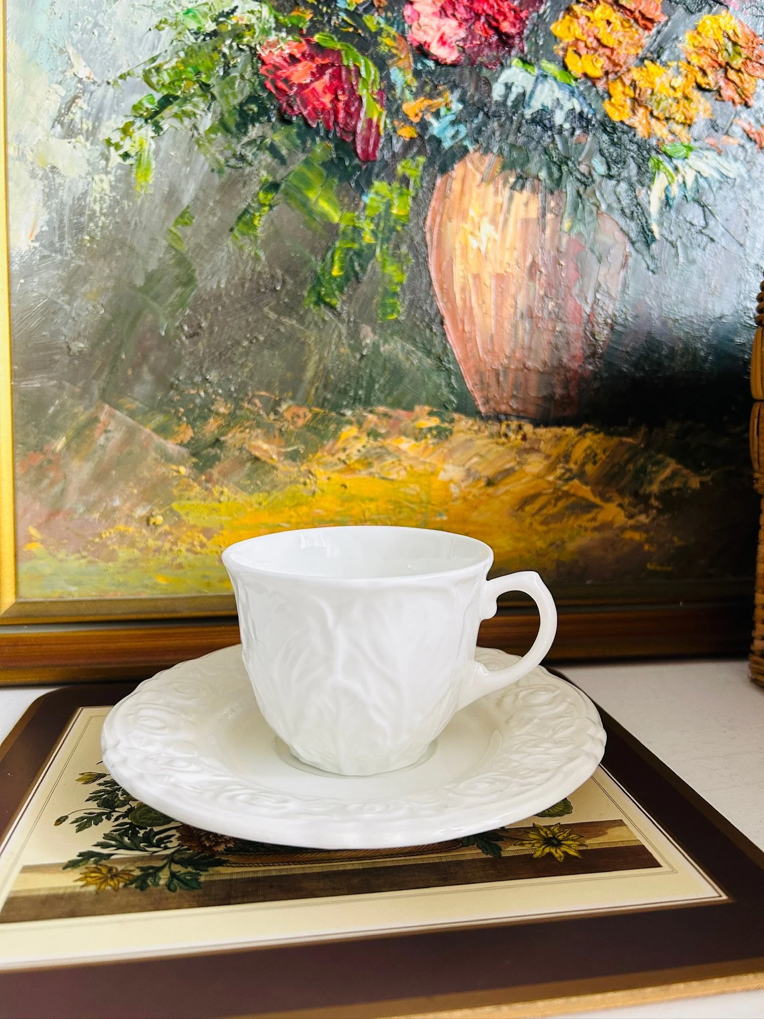 Mixed vintage cup and saucer set displayed together, featuring a white Wedgwood Country Ware cup with embossed leaf pattern and a white Franco Giorgi saucer with raised rose border.