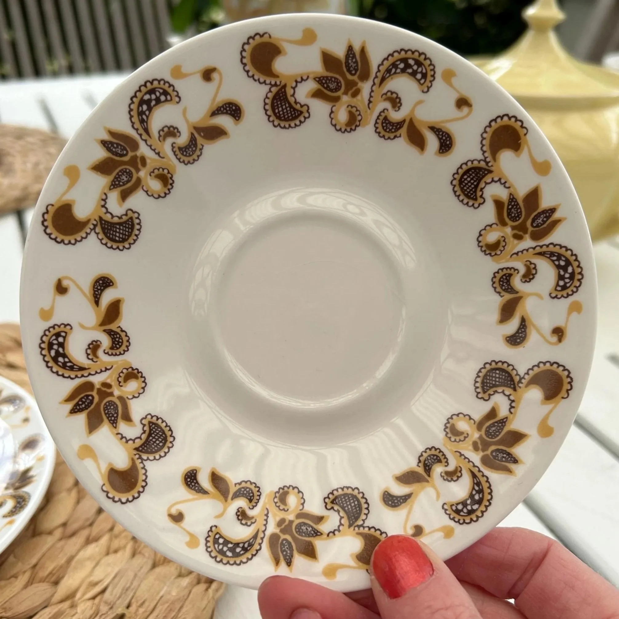Saucer detail showing repeating floral pattern and gloss finish
