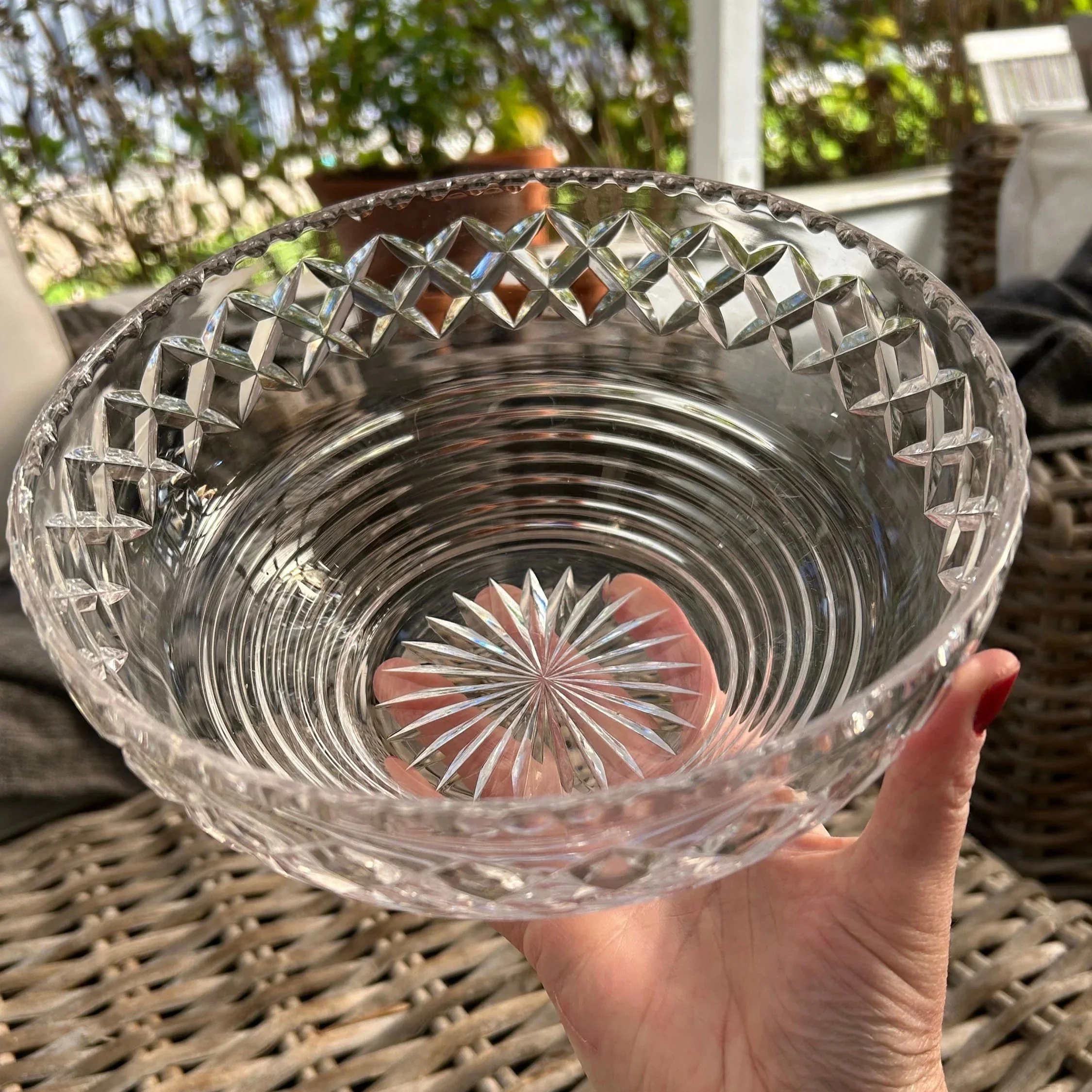Angled top view of Stuart Crystal bowl held in hand showing full interior pattern