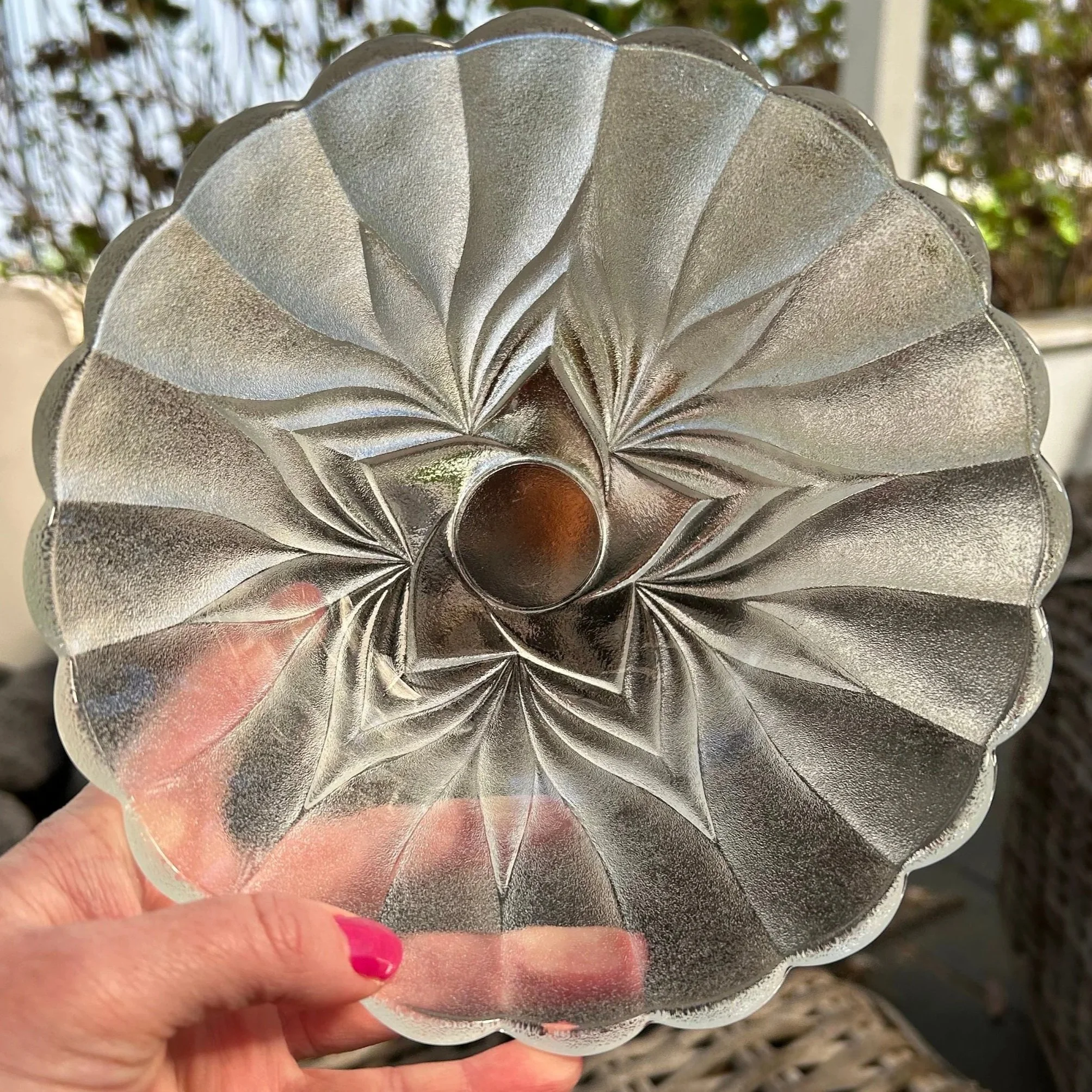 Underside view showing radiating swirl design pressed into base