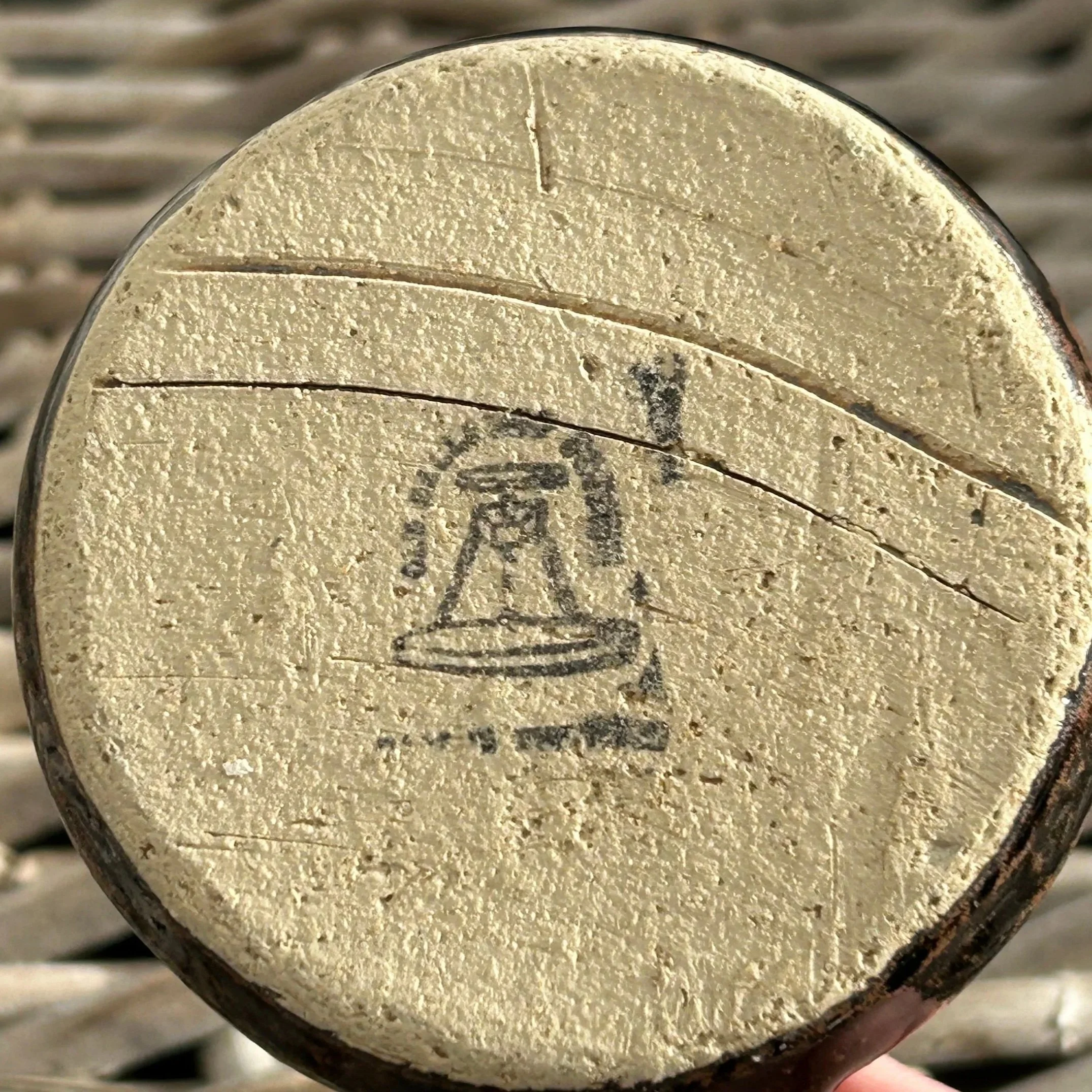 Underside showing raw clay base and maker’s mark