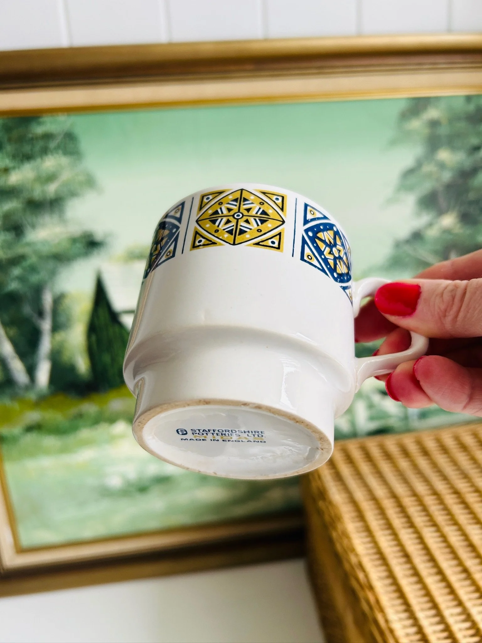 Underside angle of a Staffordshire Midas cup showing the base shape and part of the maker’s mark.