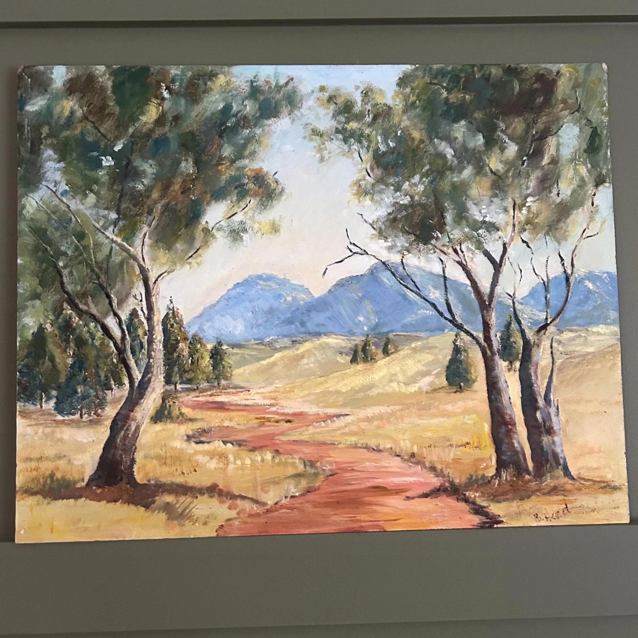 Original oil on board by B. Head. Serene Australian outback scene with gumtrees, dirt path, and mountain backdrop. A richly textured, vintage landscape.