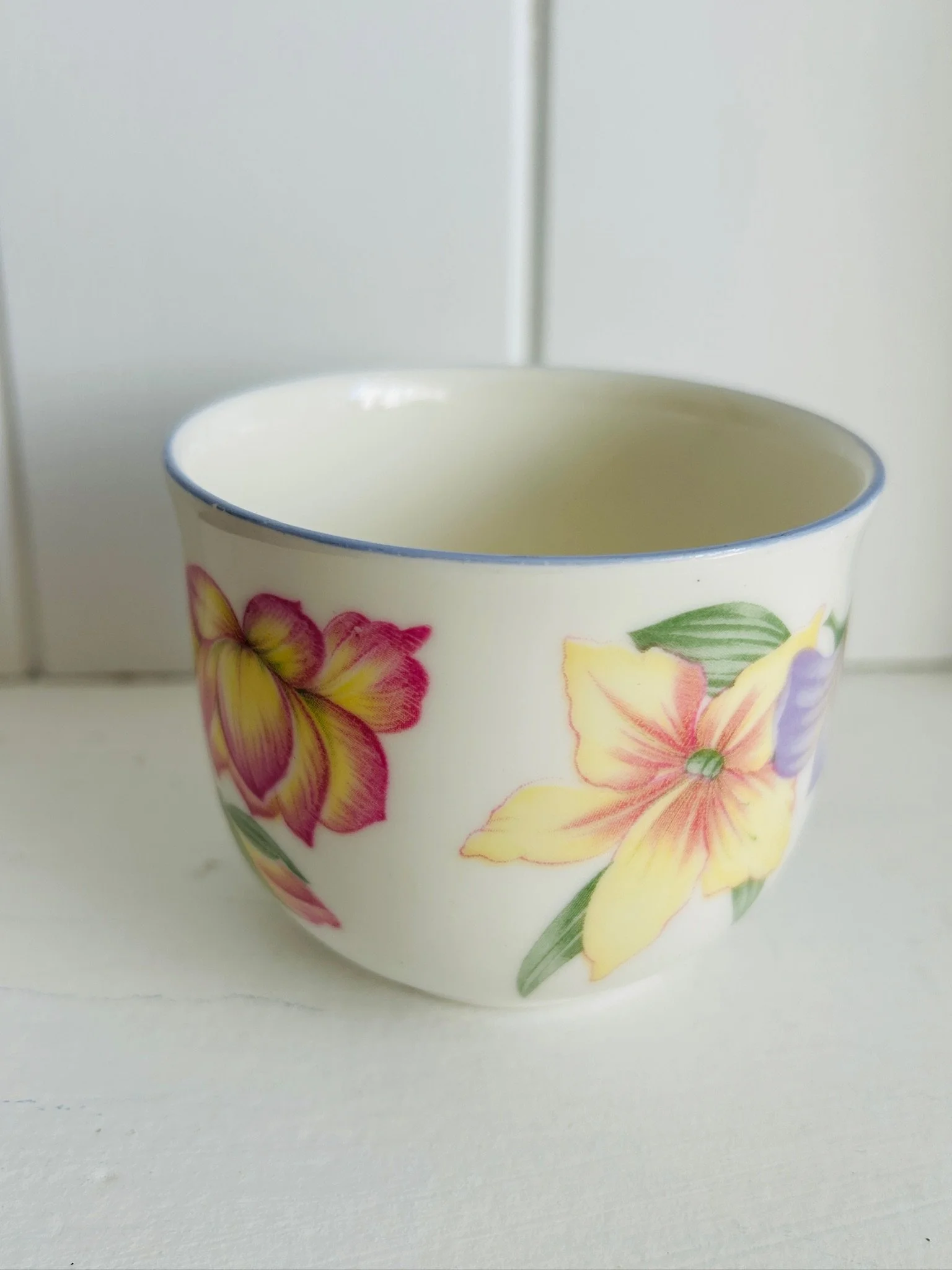 Close side view of the Royal Doulton Blooms teacup, highlighting the large pastel flower motif and delicate blue rim