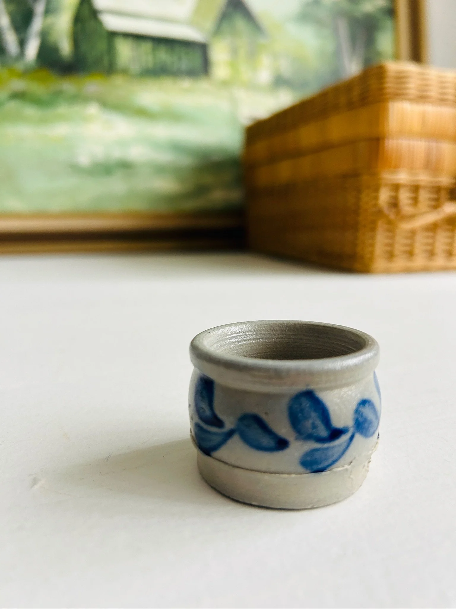Distant view of the petite blue leaf salt cellar on a white surface, showing its small scale in context