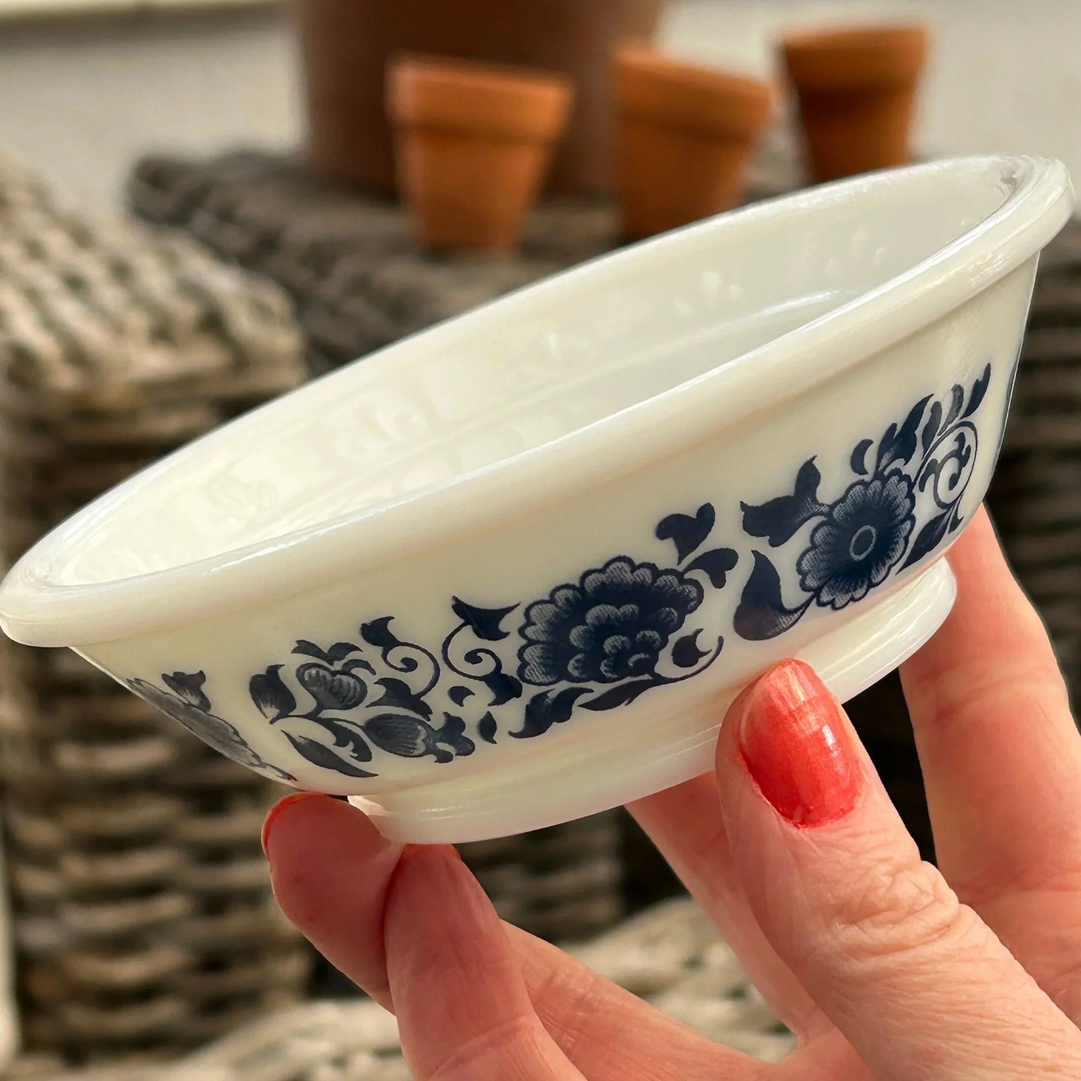 Side angle of bowl held in hand, showing detailed floral motif