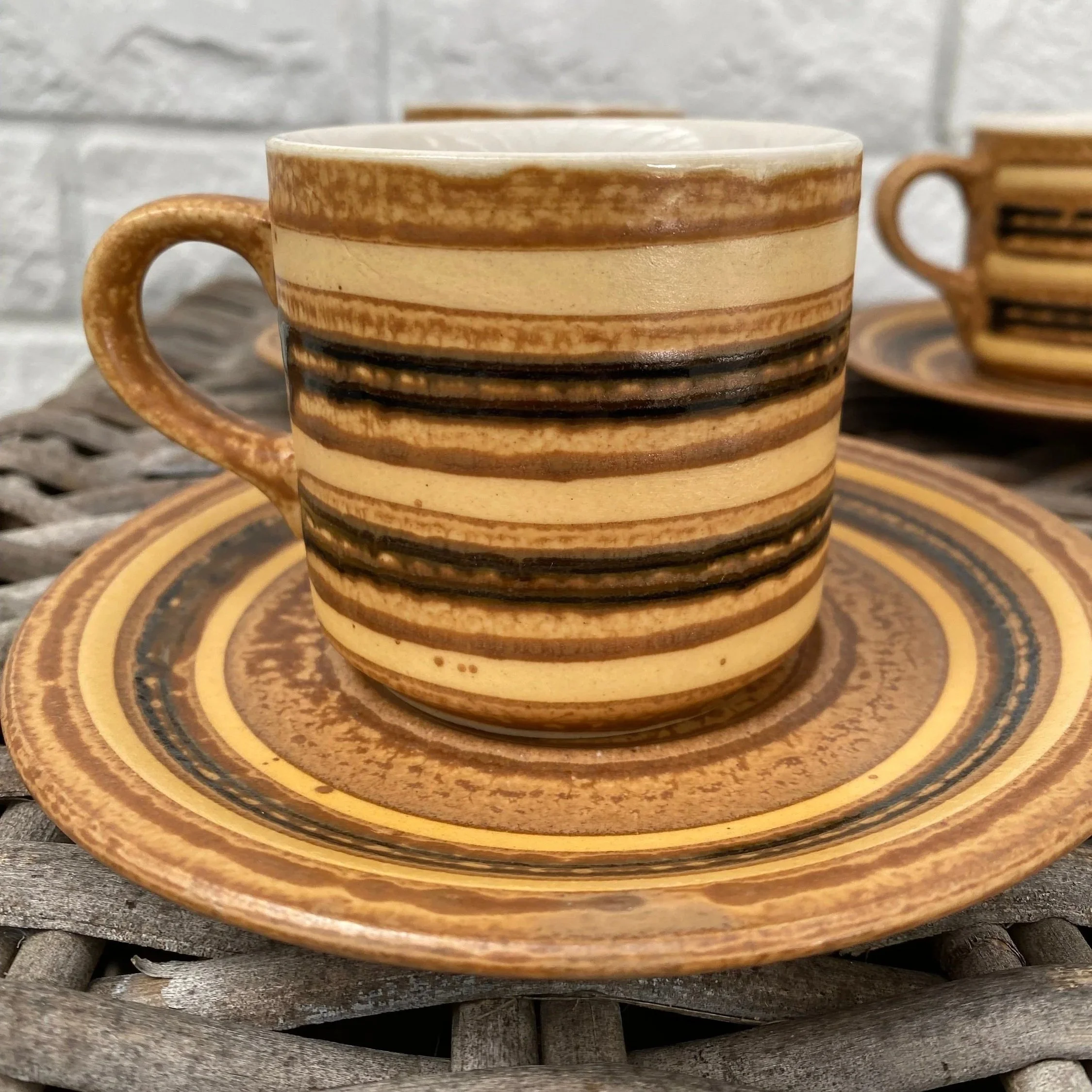 Close-up of coffee cup and saucer showing textured glaze