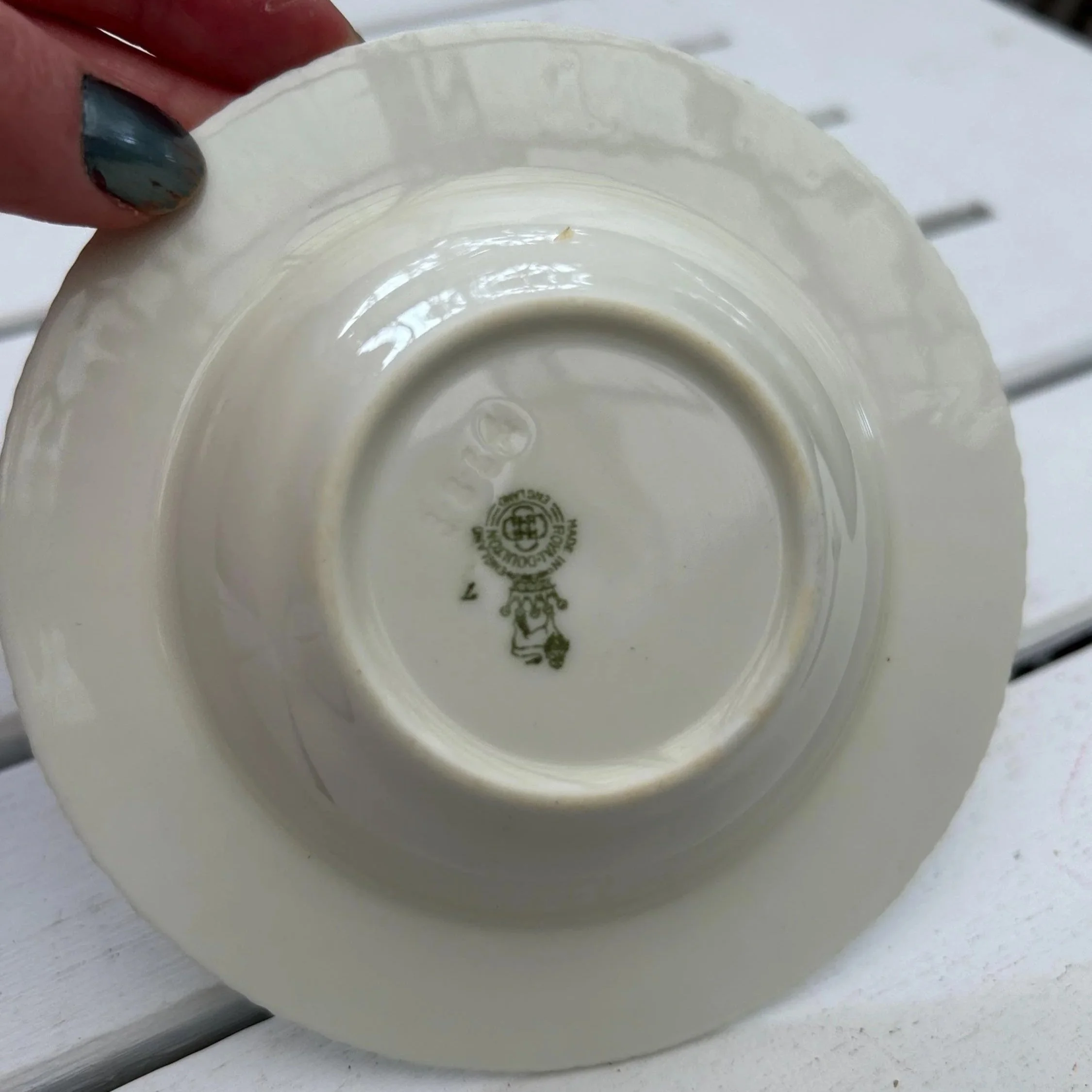 Underside view of dish on table showing condition and backstamp