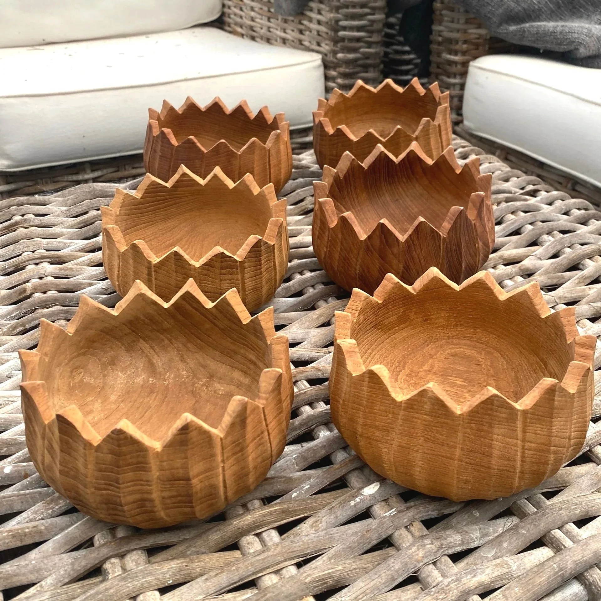 Full set of six vintage teak salad bowls on wicker table