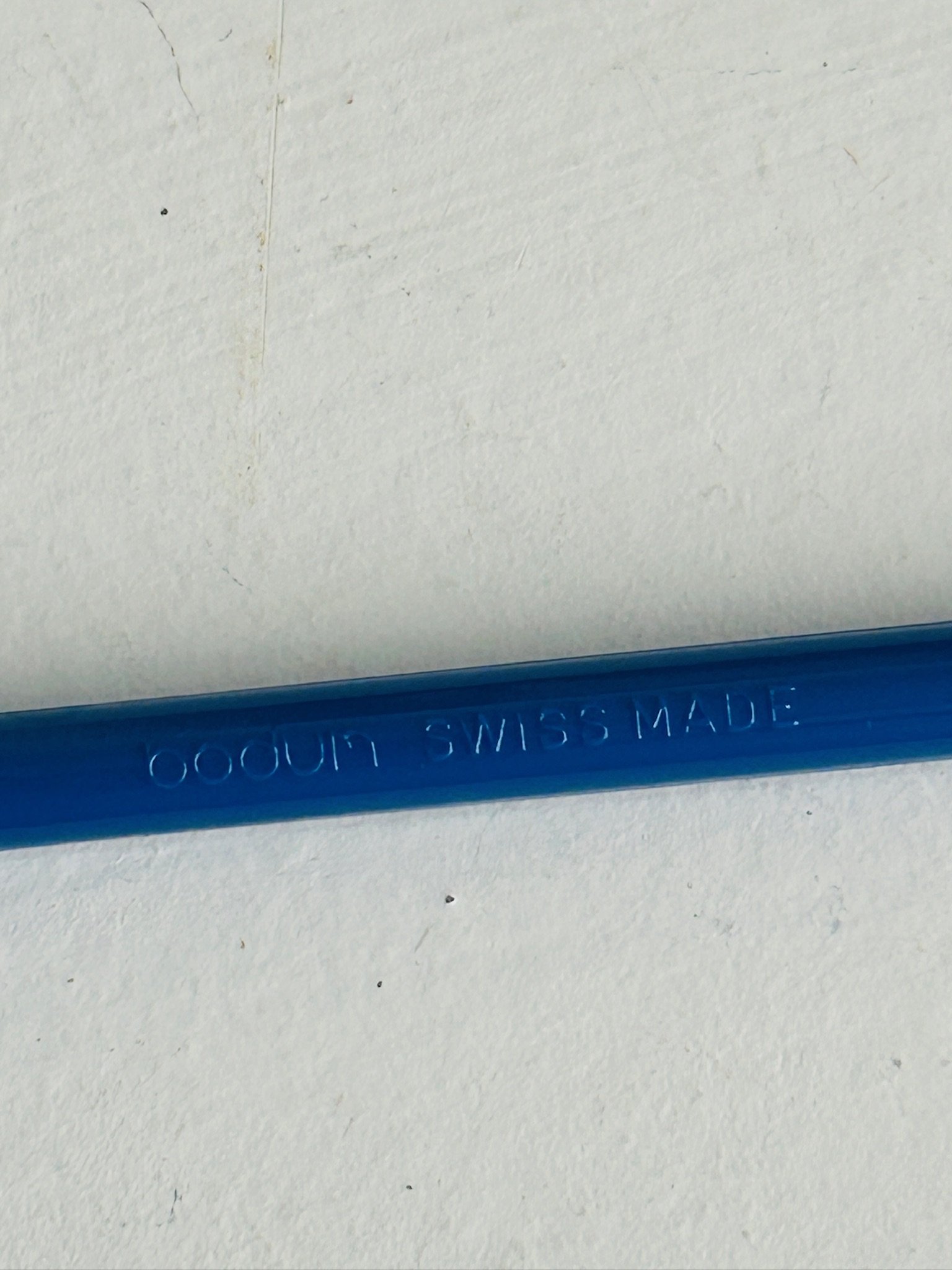 Close-up of the handle embossing reading BODUM SWISS MADE on a blue plastic stir spoon