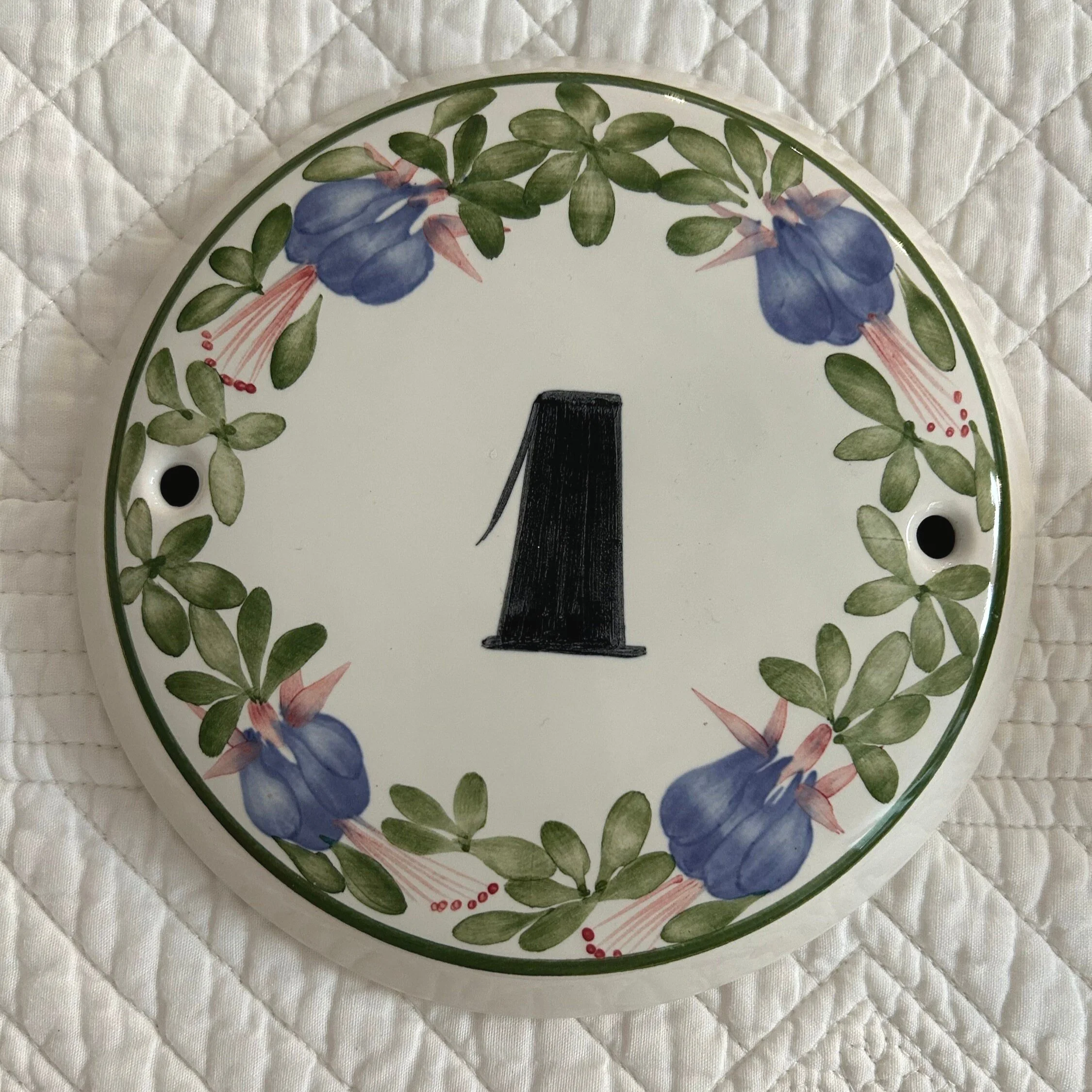 Front of Cinque Ports Pottery ceramic house number plaque with hand-painted purple fuchsia and green leaves around number 1