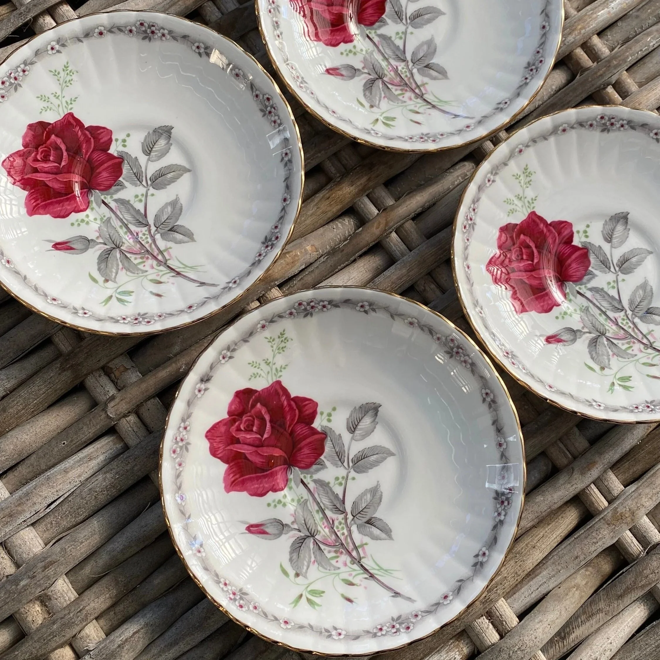 Top-down group shot of 4 Royal Stafford “Roses to Remember” saucers with red rose motif
