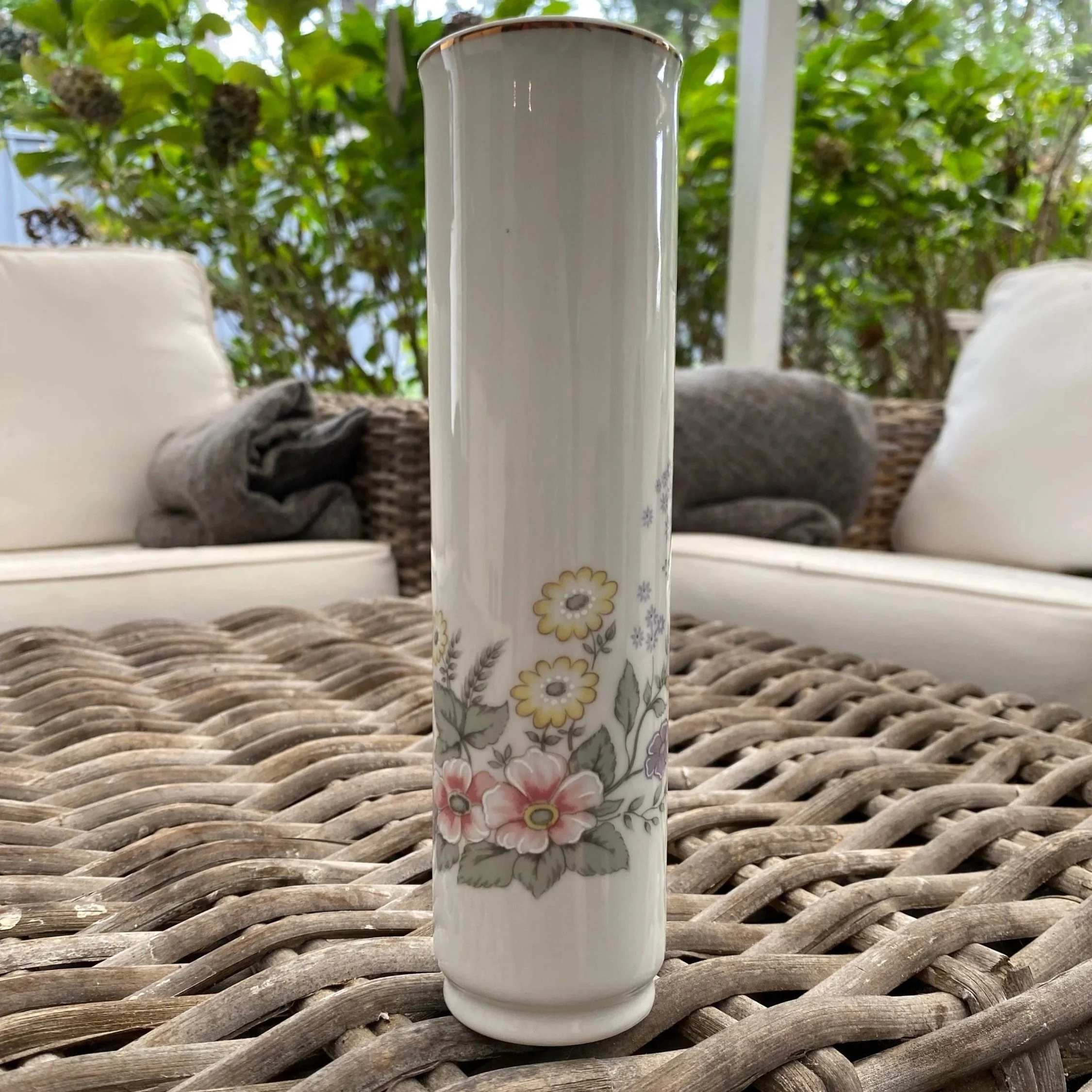 Full front view of tall white porcelain vase with pastel floral design
