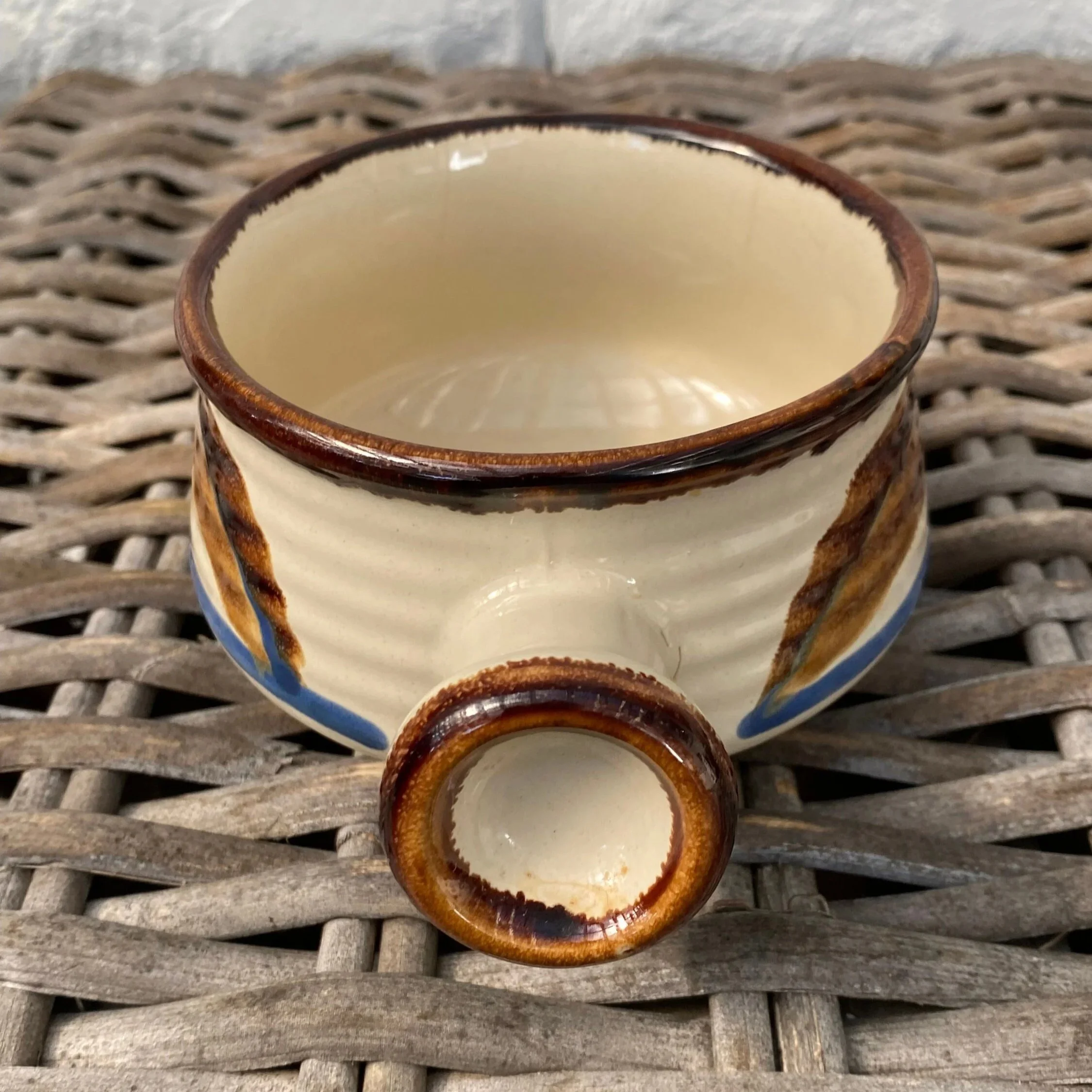 Angled front view showing the circular handle opening and cream glazed interior