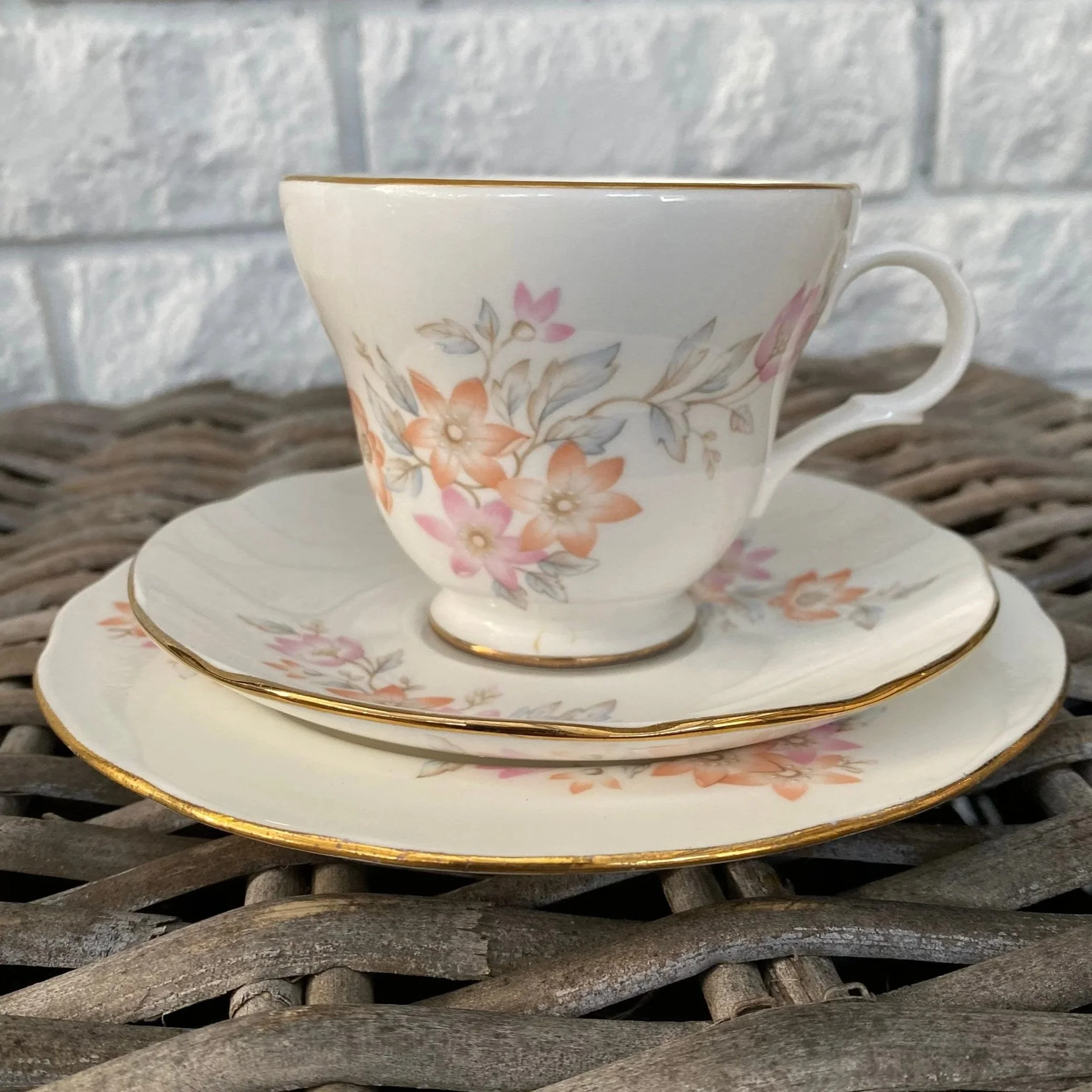 Full trio set showing teacup, saucer, and plate with floral design