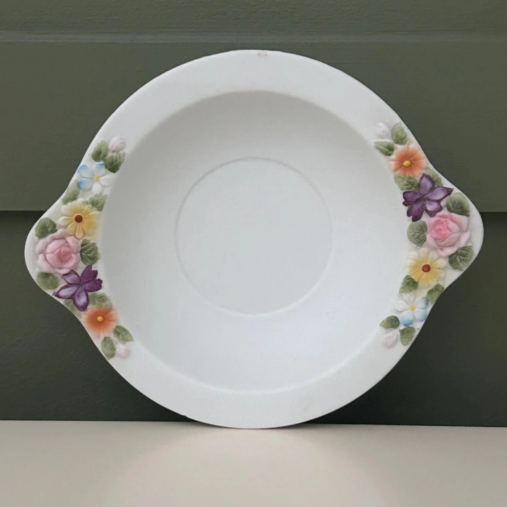 Shallow handled bowl with floral decoration on rim