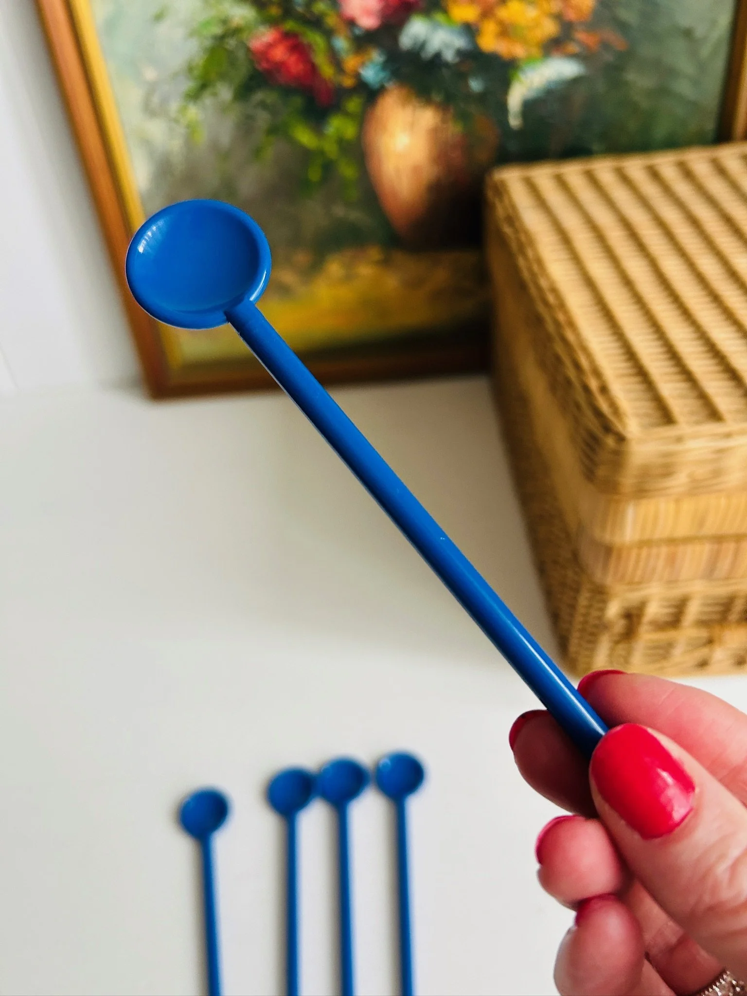 Single blue Bodum stir spoon held in hand, showing the full length and slim handle