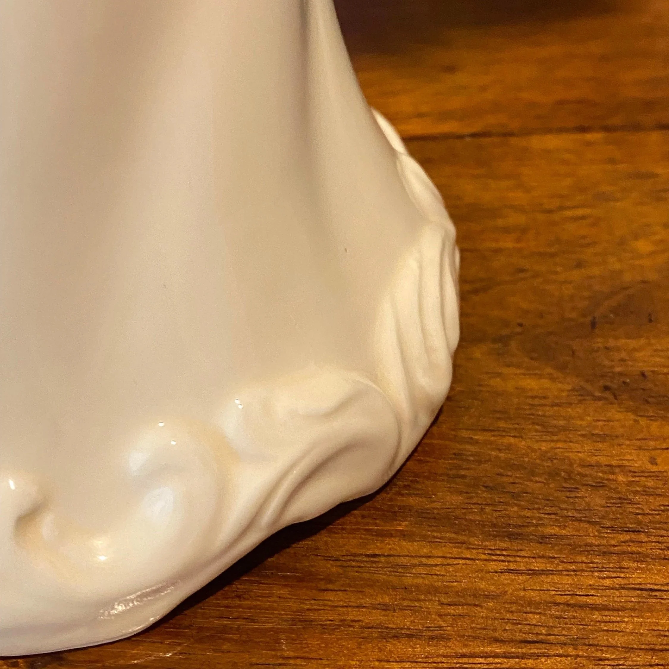 Detail of sculpted porcelain base with smooth glossy glaze