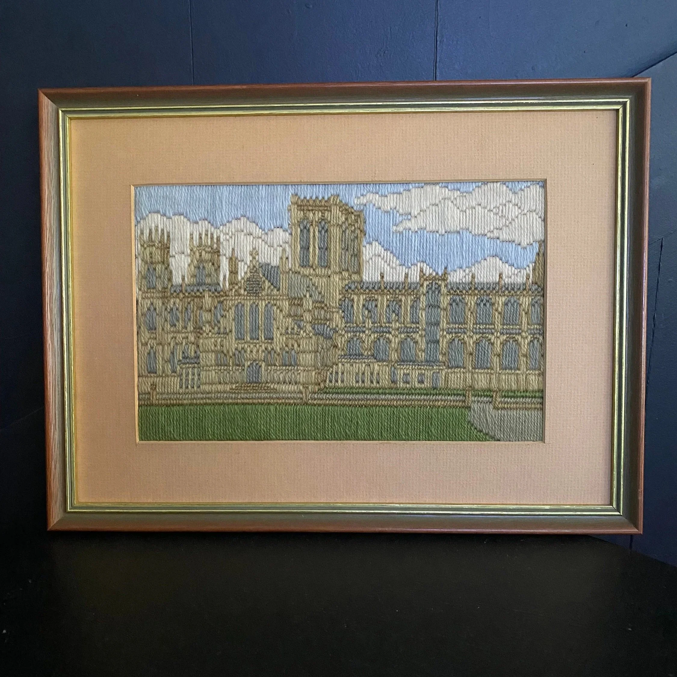 Framed vintage long stitch artwork of York Minster shown from the front with pink-toned matting and wood-effect frame
