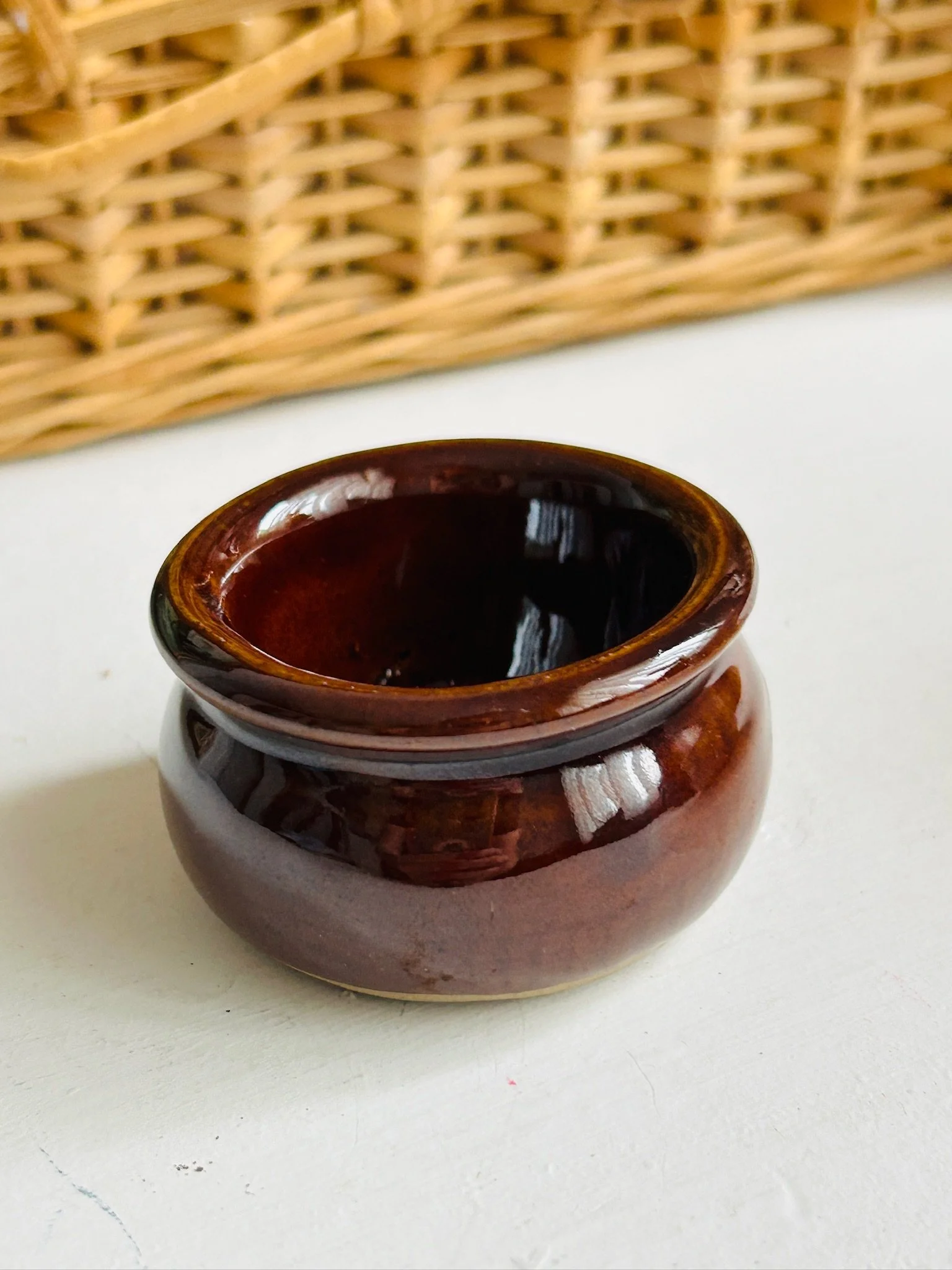 Three-quarter top view of the brown glazed condiment pot showing its glossy finish and open shape