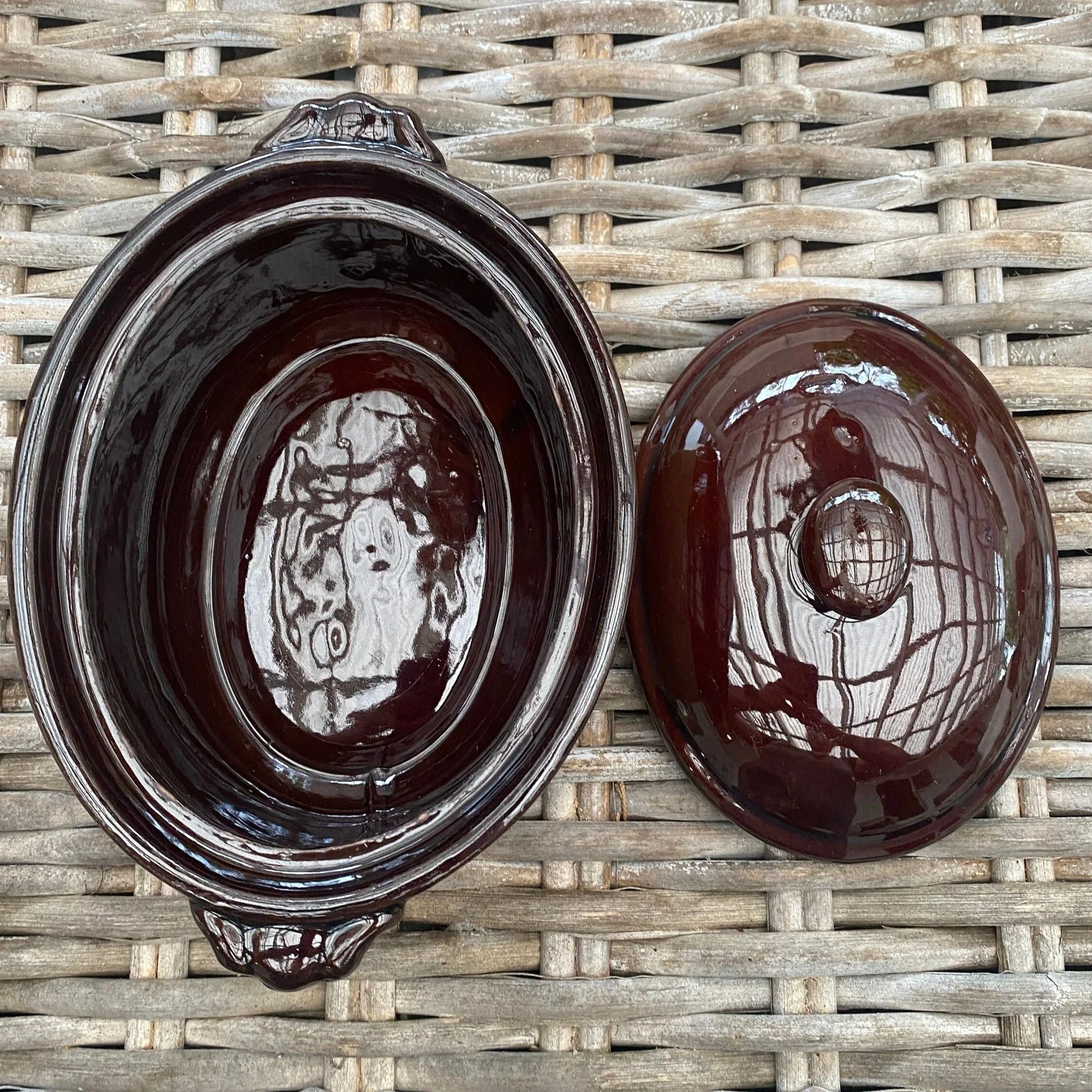 Top view of the oval ceramic pot with lid removed, showing the interior and matching glazed lid