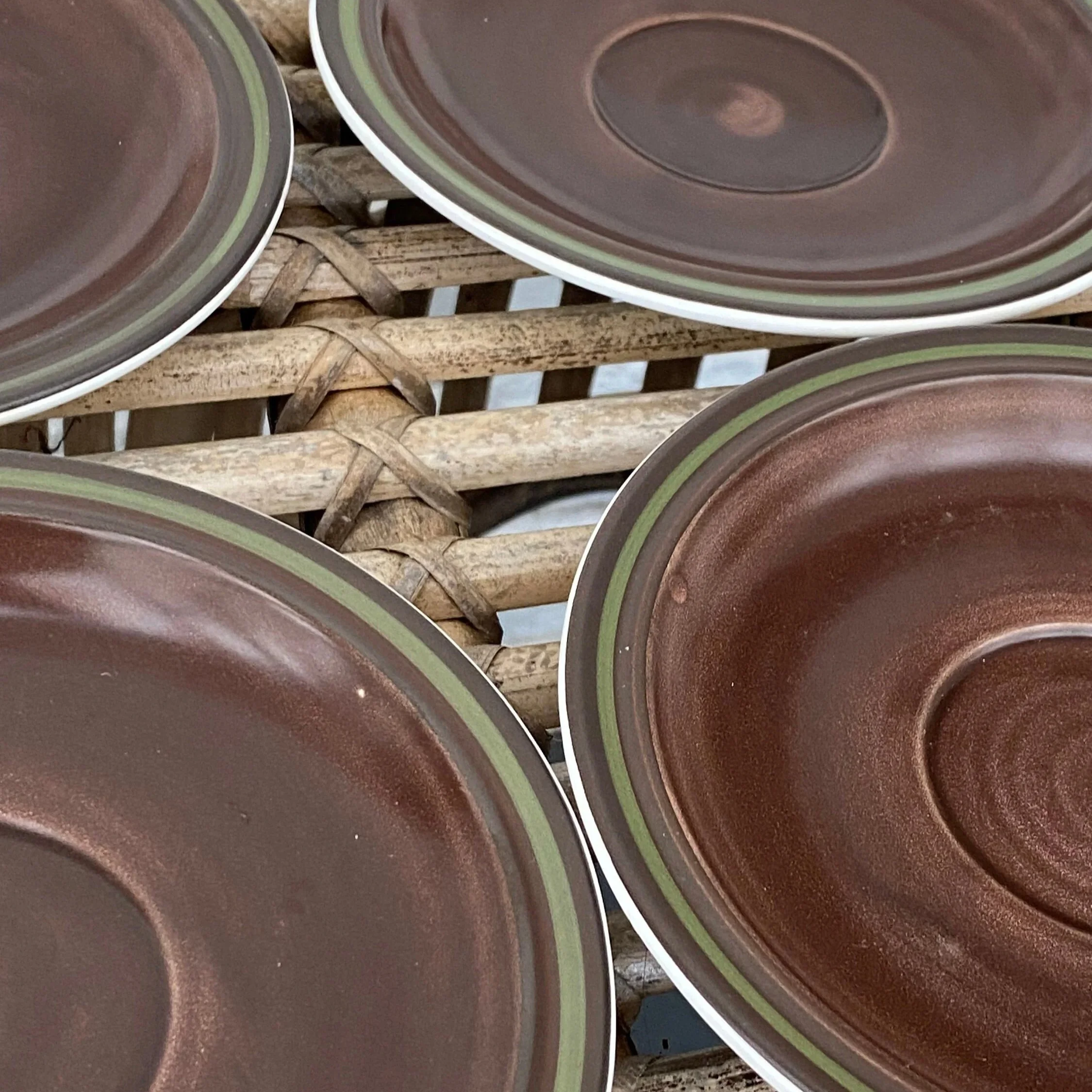 Close-up of brown Electra saucers showing olive green rim and glossy glaze