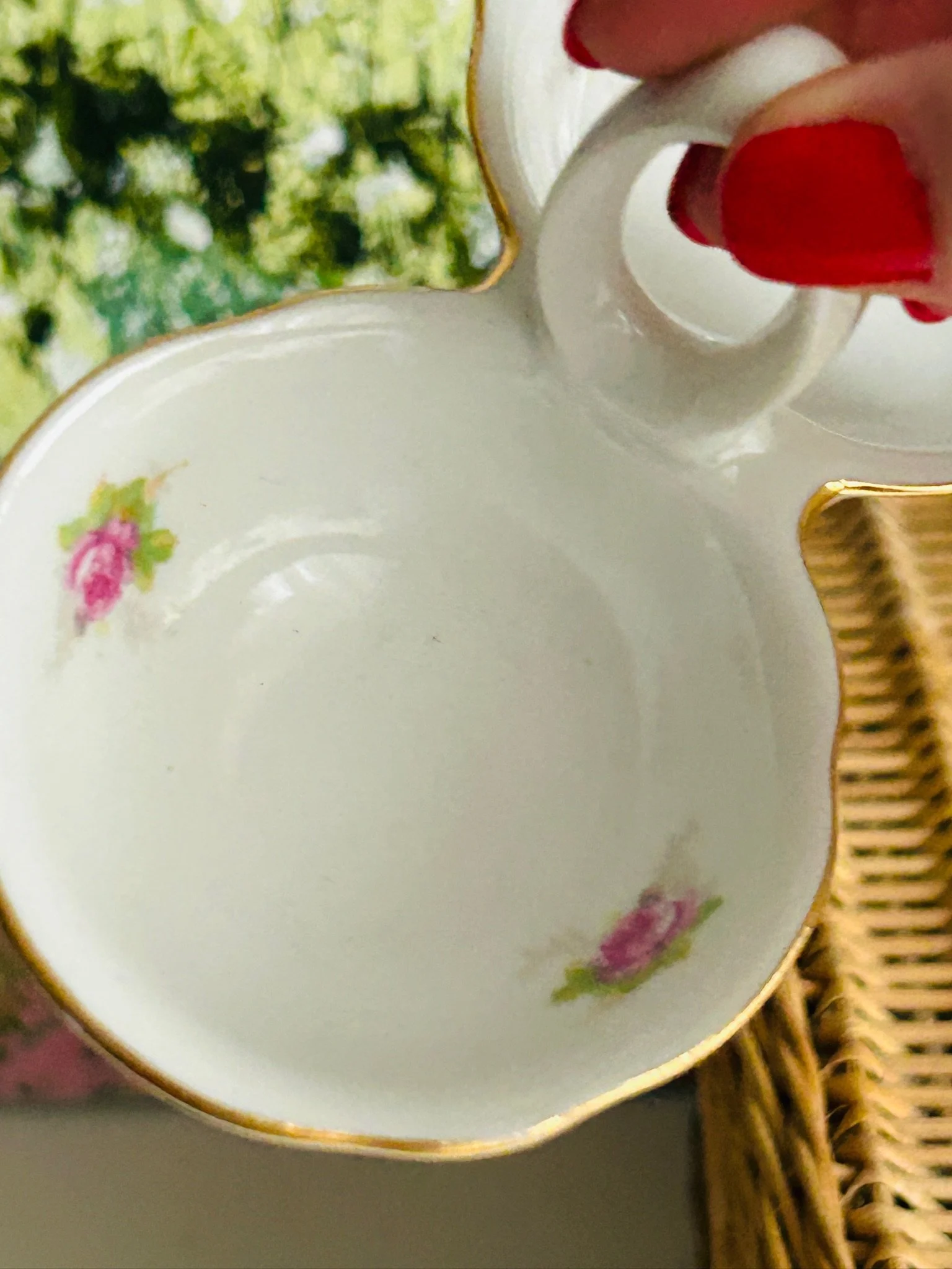 Close-up of the interior of one bowl with two pink rose motifs and gold trim