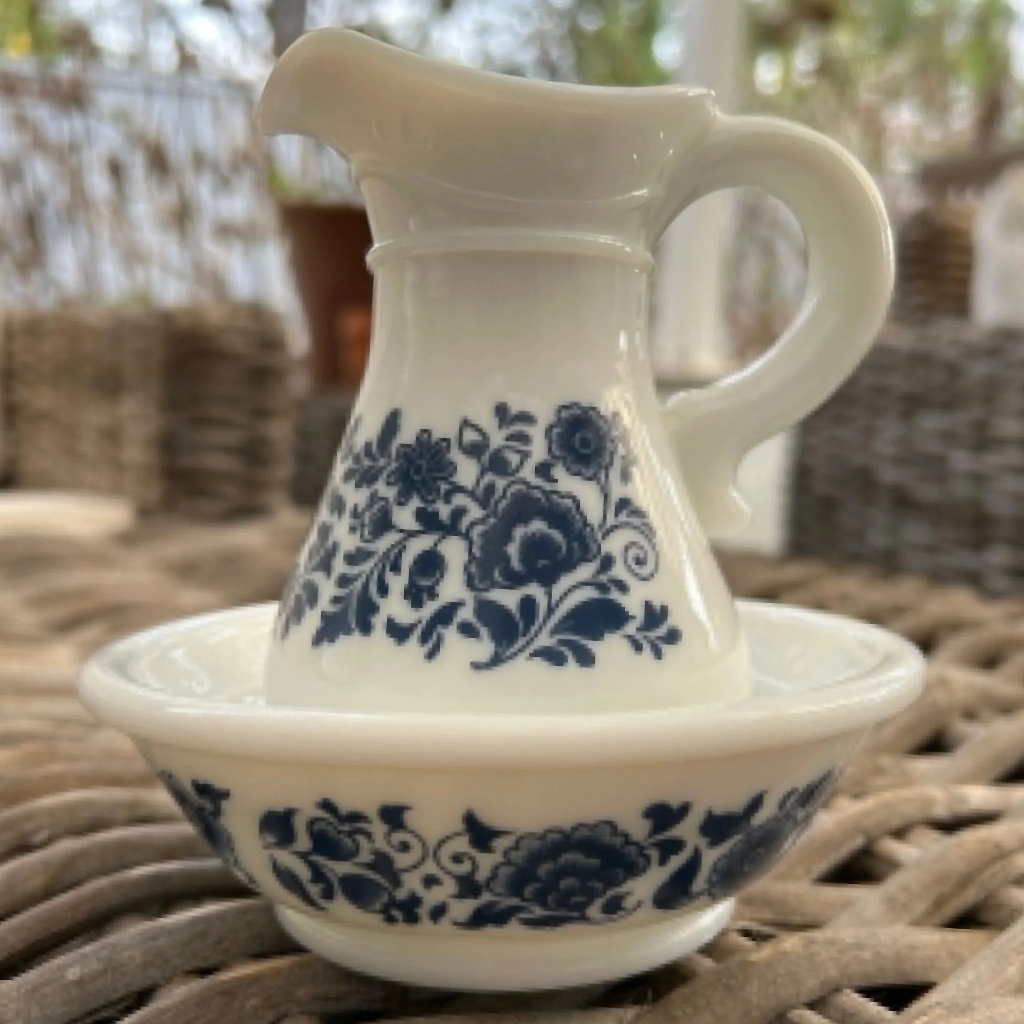 Full view of Avon milk glass pitcher with matching bowl featuring blue floral design