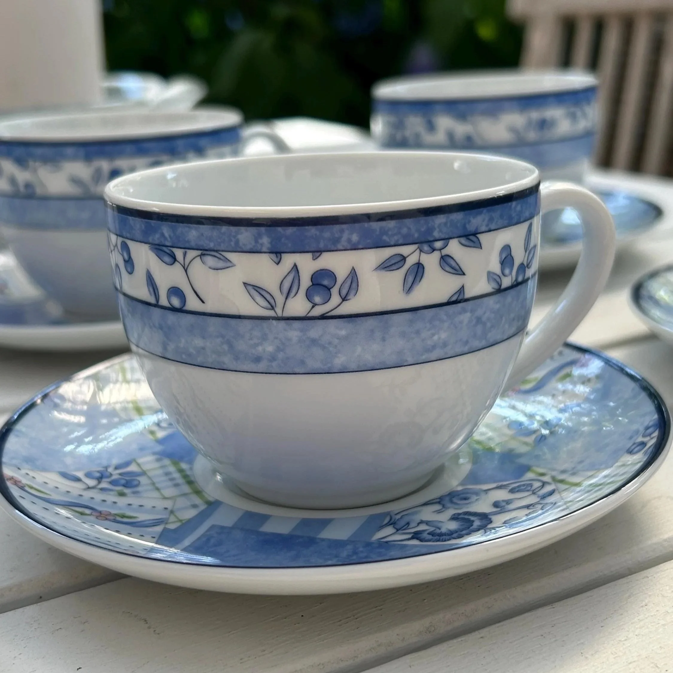 Close-up of a Wedgwood Indigo teacup on its saucer showing the blue floral border and patchwork saucer design