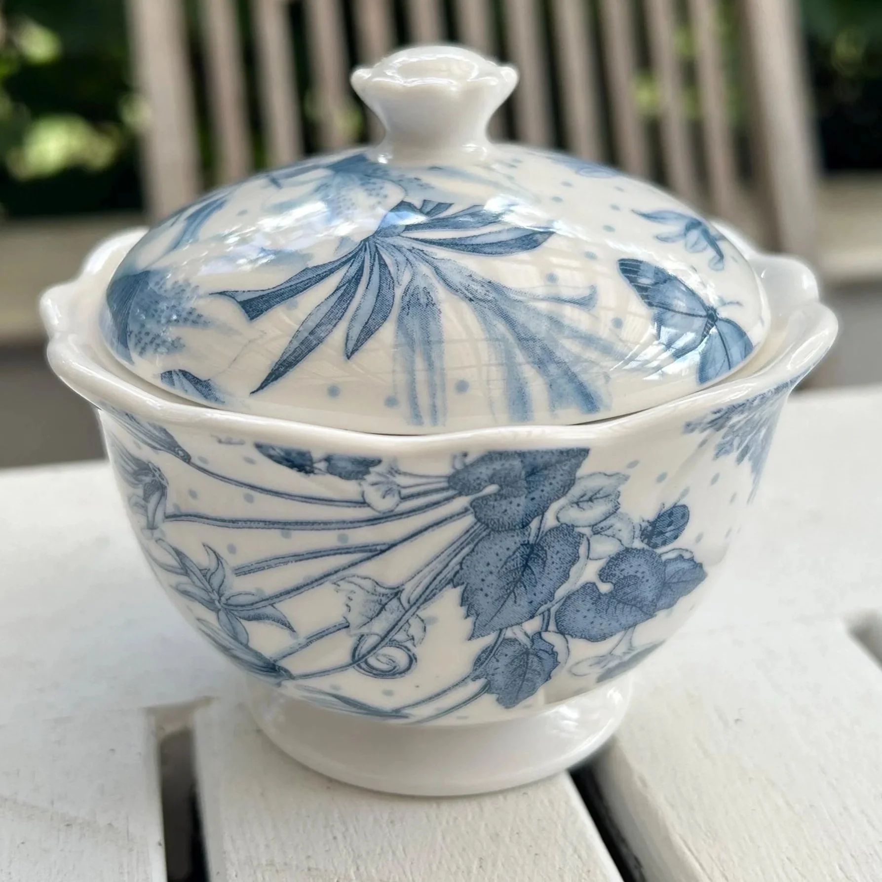 Close-up side view showing floral blue pattern and lid finial