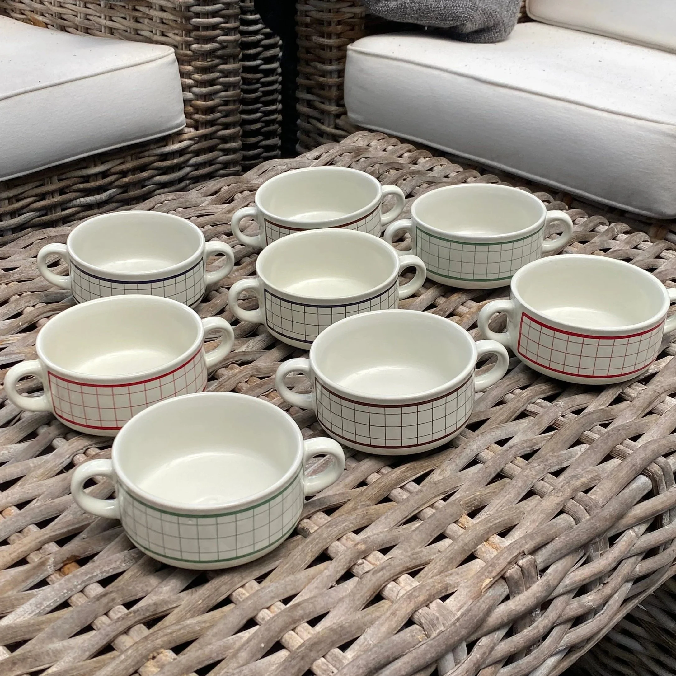 Group of matching soup mugs arranged on wicker table
