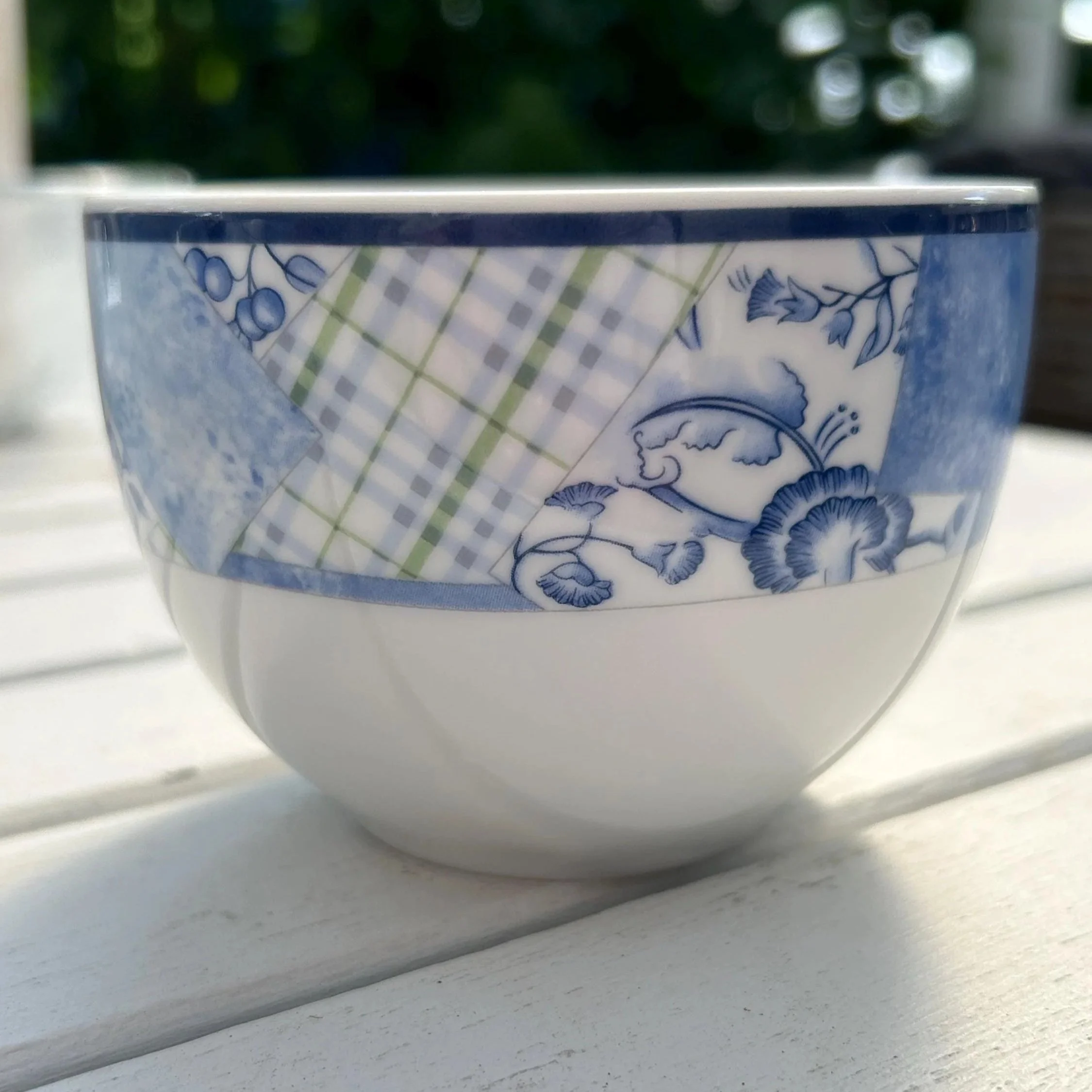 Close-up of the sugar bowl side showing the blue patchwork band on fine white porcelain