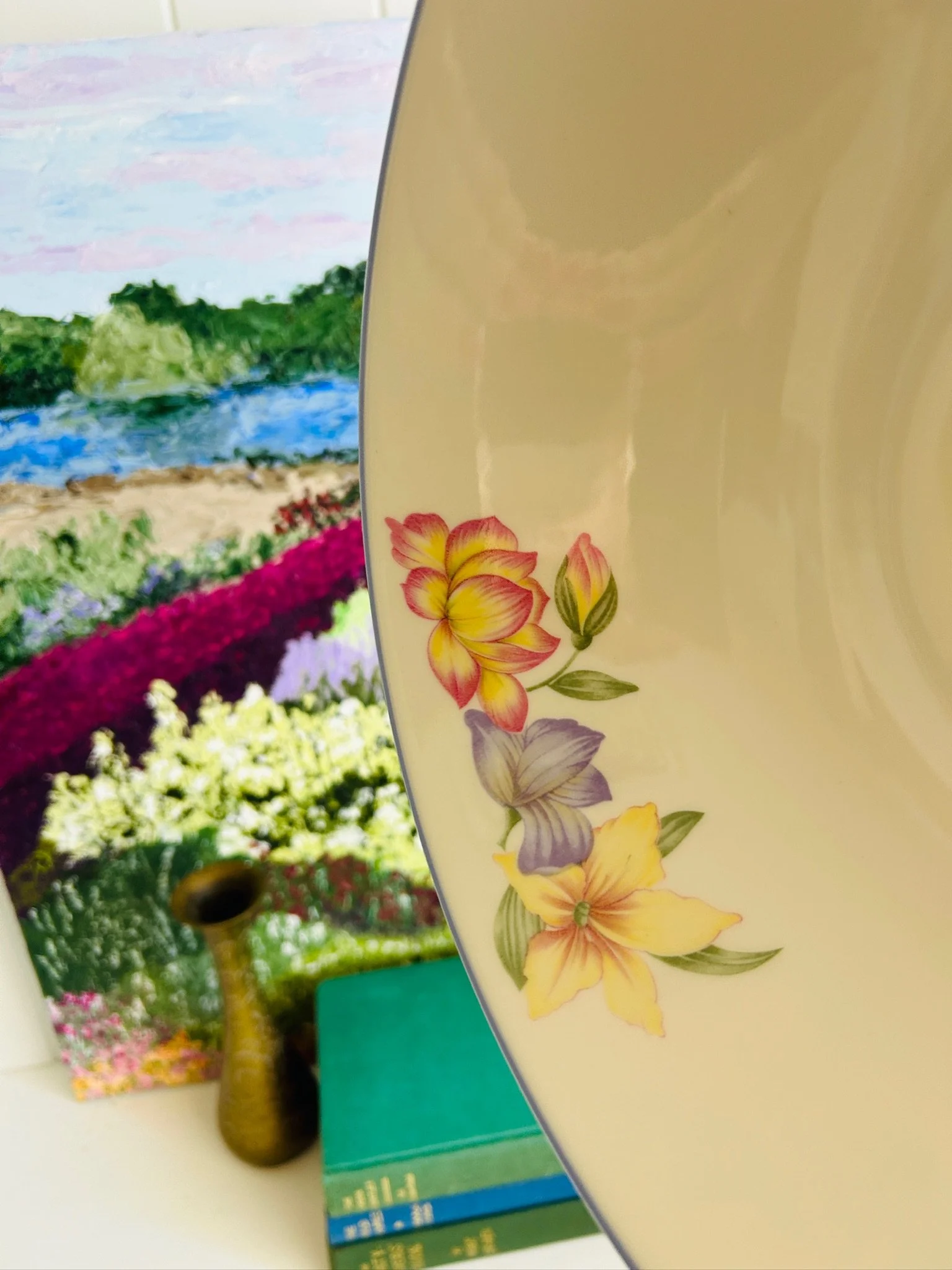 Close-up of the bowl interior and rim, showing the pale glaze and small paint mark near the floral border