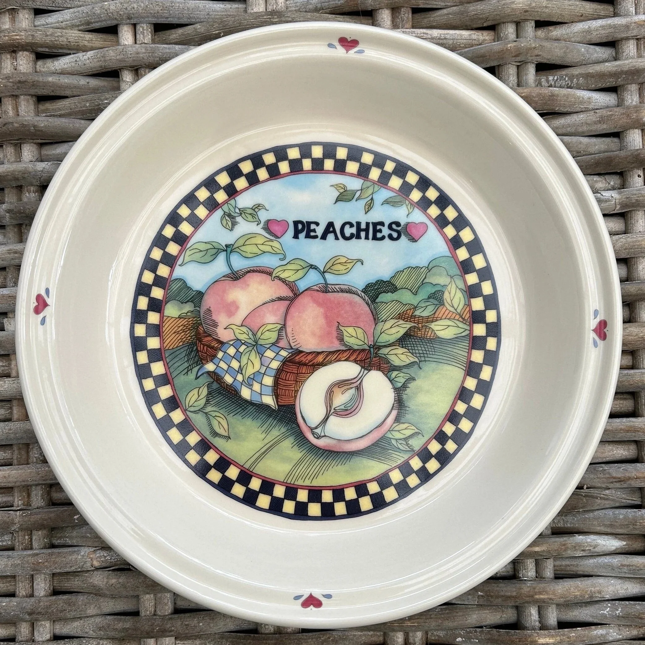 Overhead view of ceramic pie dish featuring a peach motif and heart details