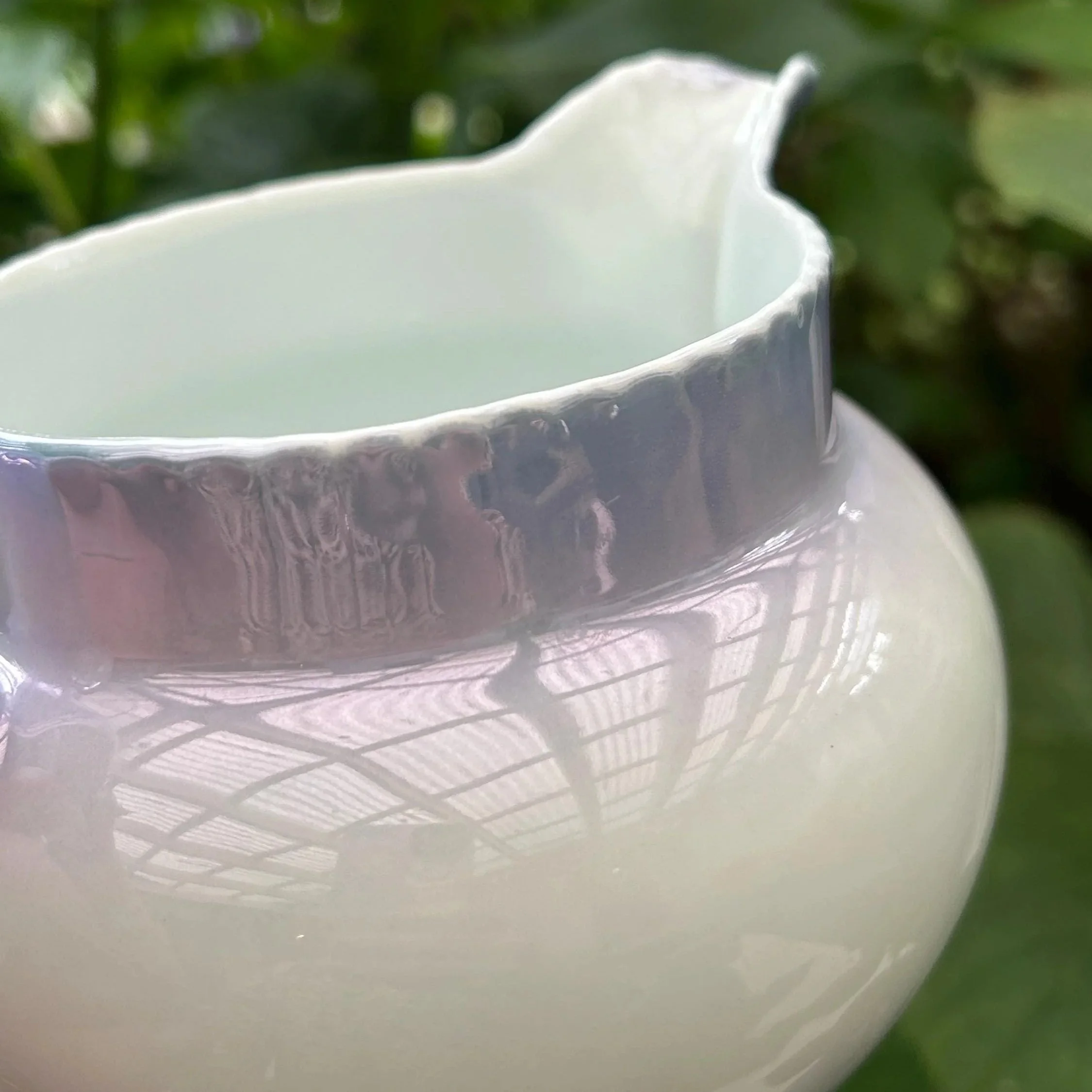 : Close-up of ruffled rim and soft iridescent glaze under natural light