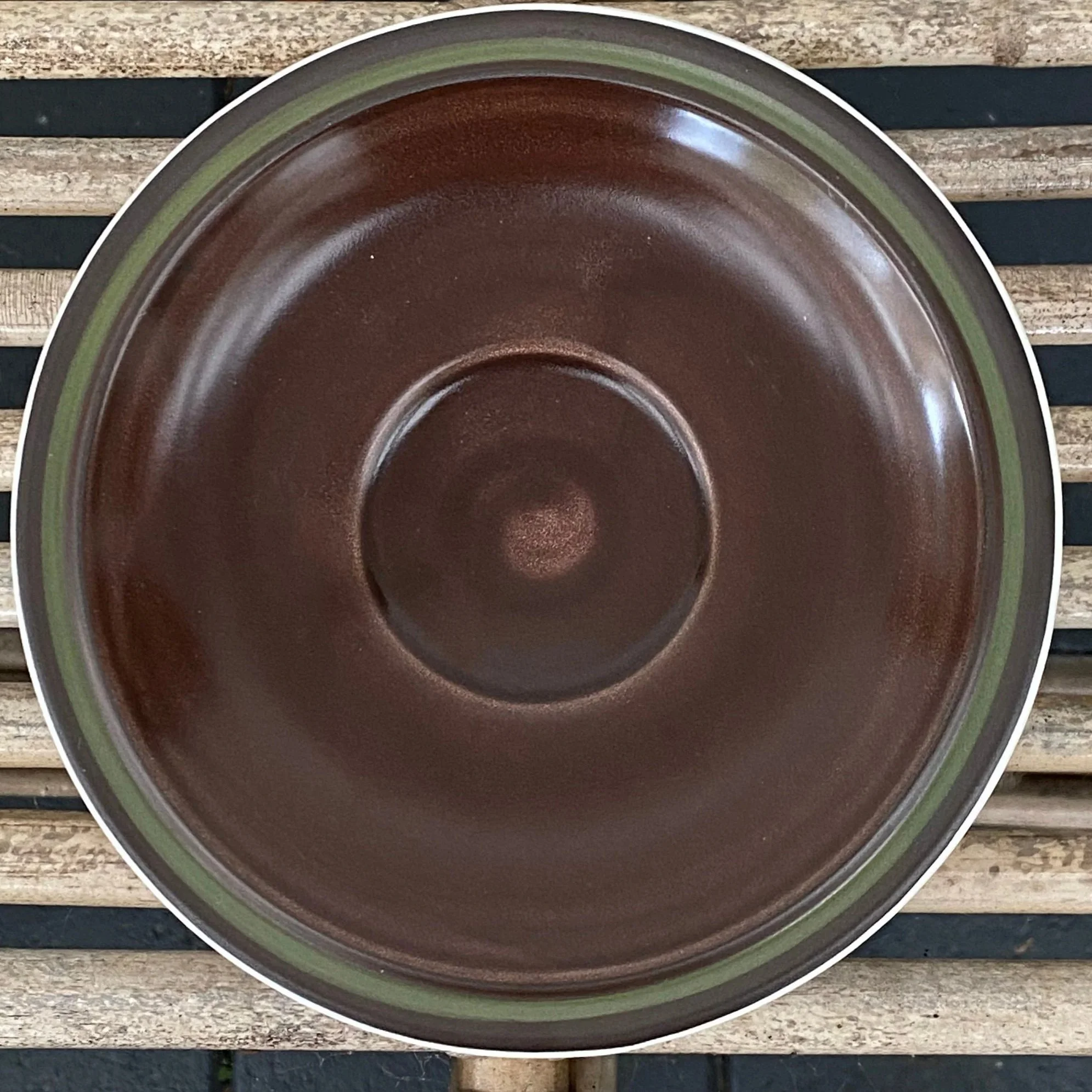 Overhead view of a single saucer showing swirl pattern and central cup ring
