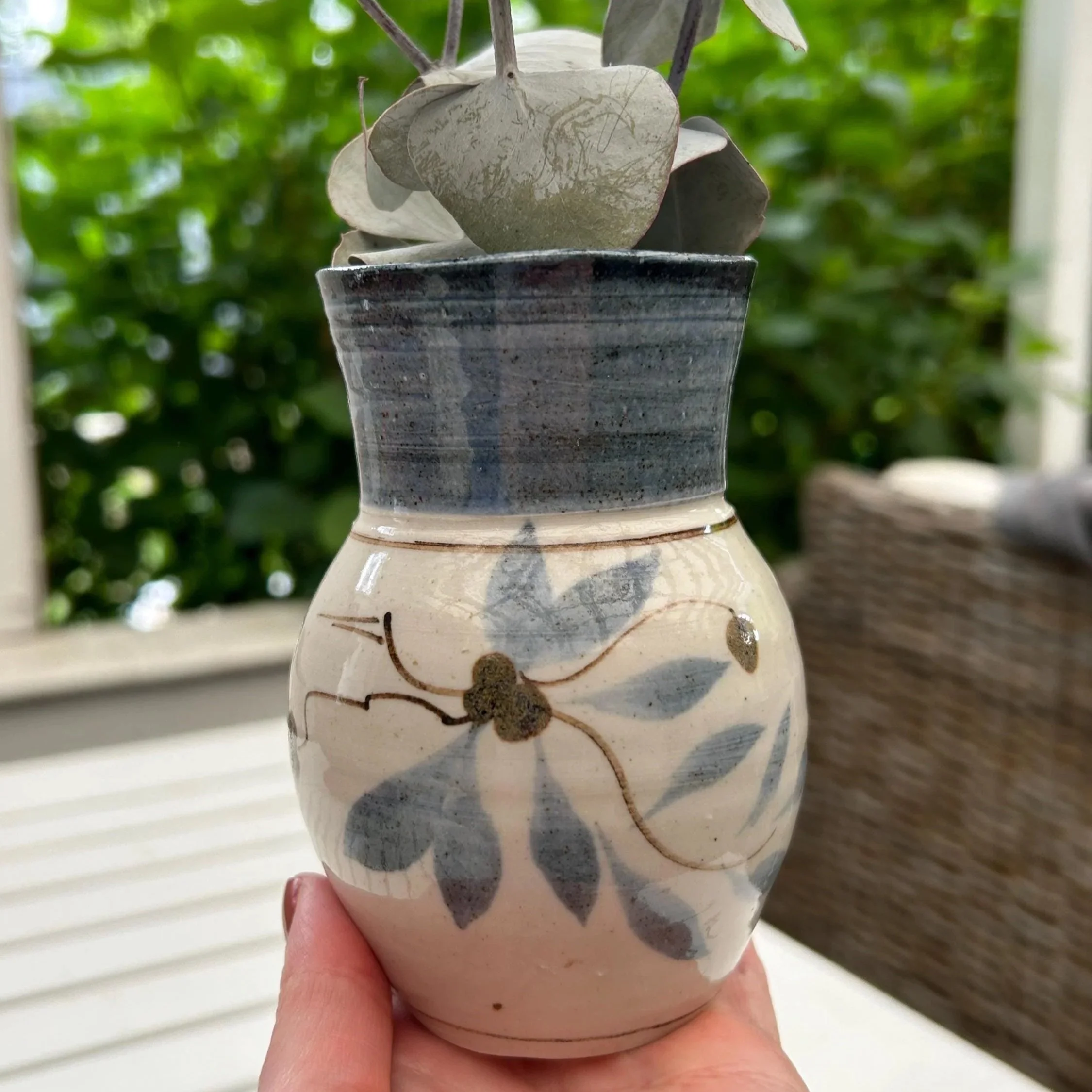 Full view of blue and beige Edinburgh Pottery ceramic vase with eucalyptus stems