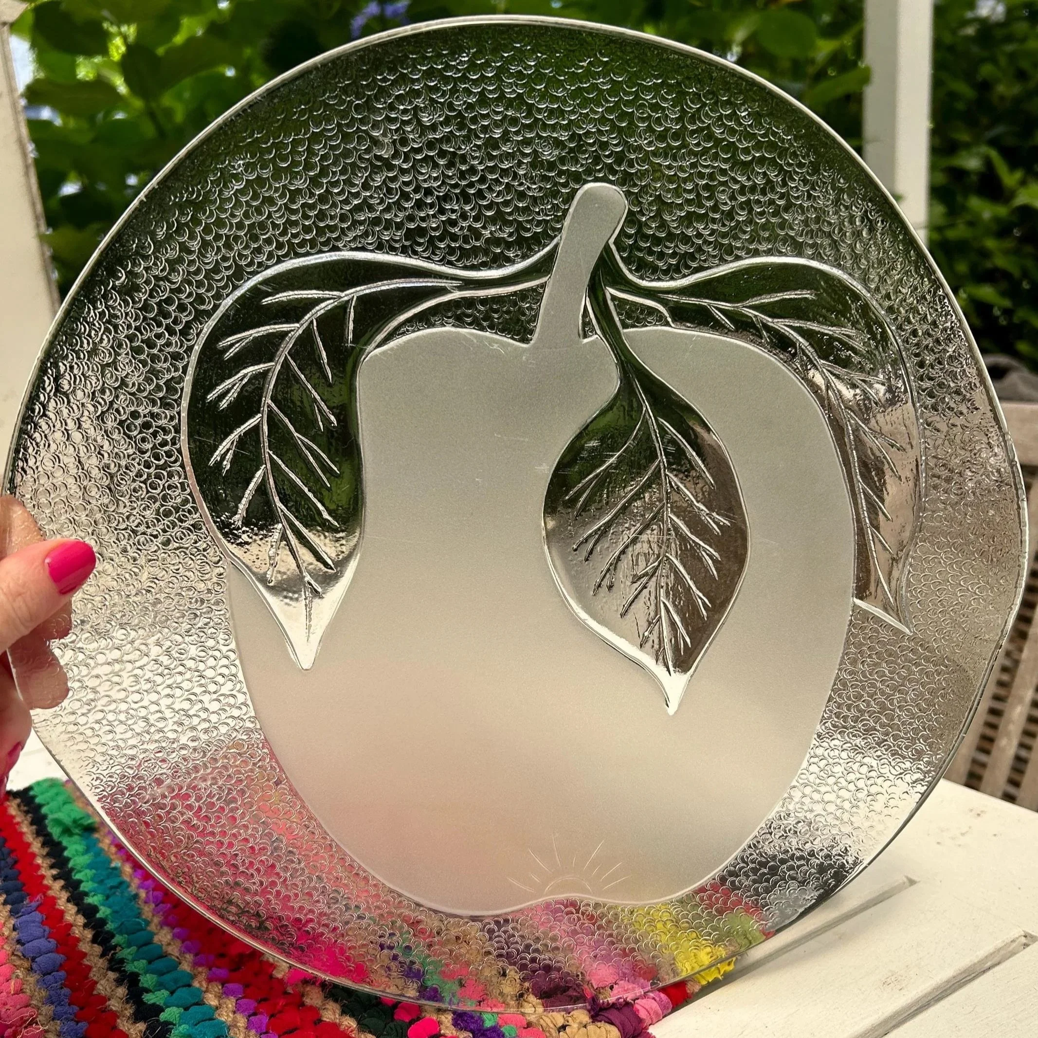 Frosted apple-design IVV Italian glass platter held up to show textured rim.