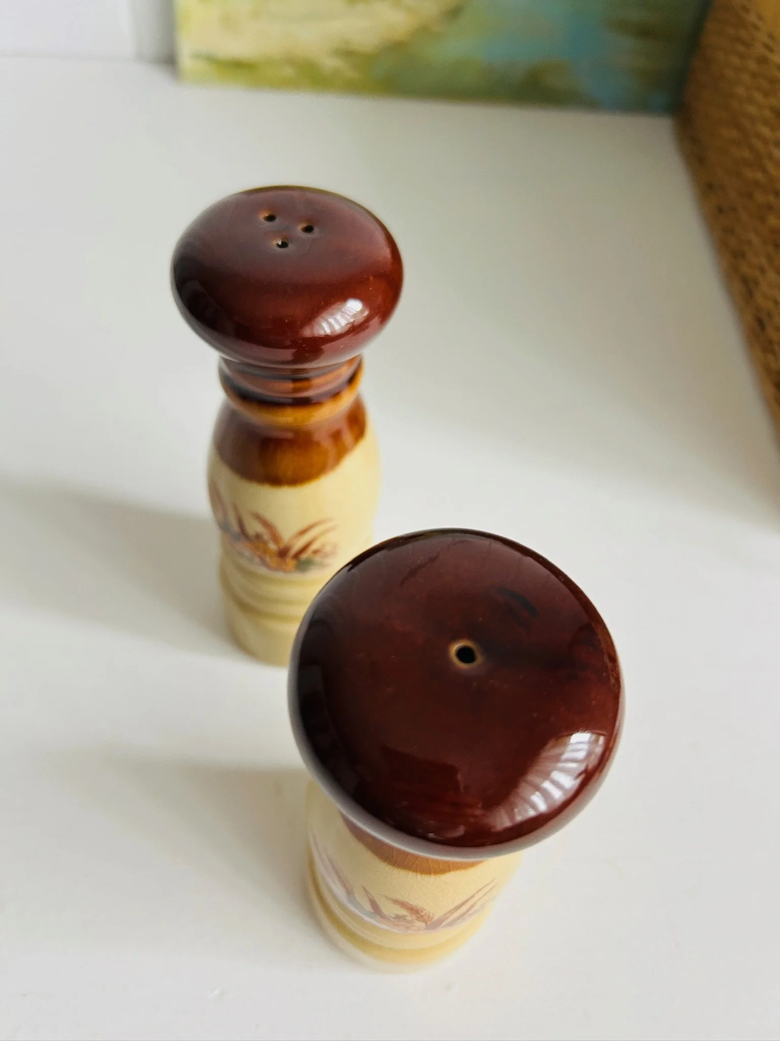 Top view of both shakers showing different hole patterns in the brown glazed tops