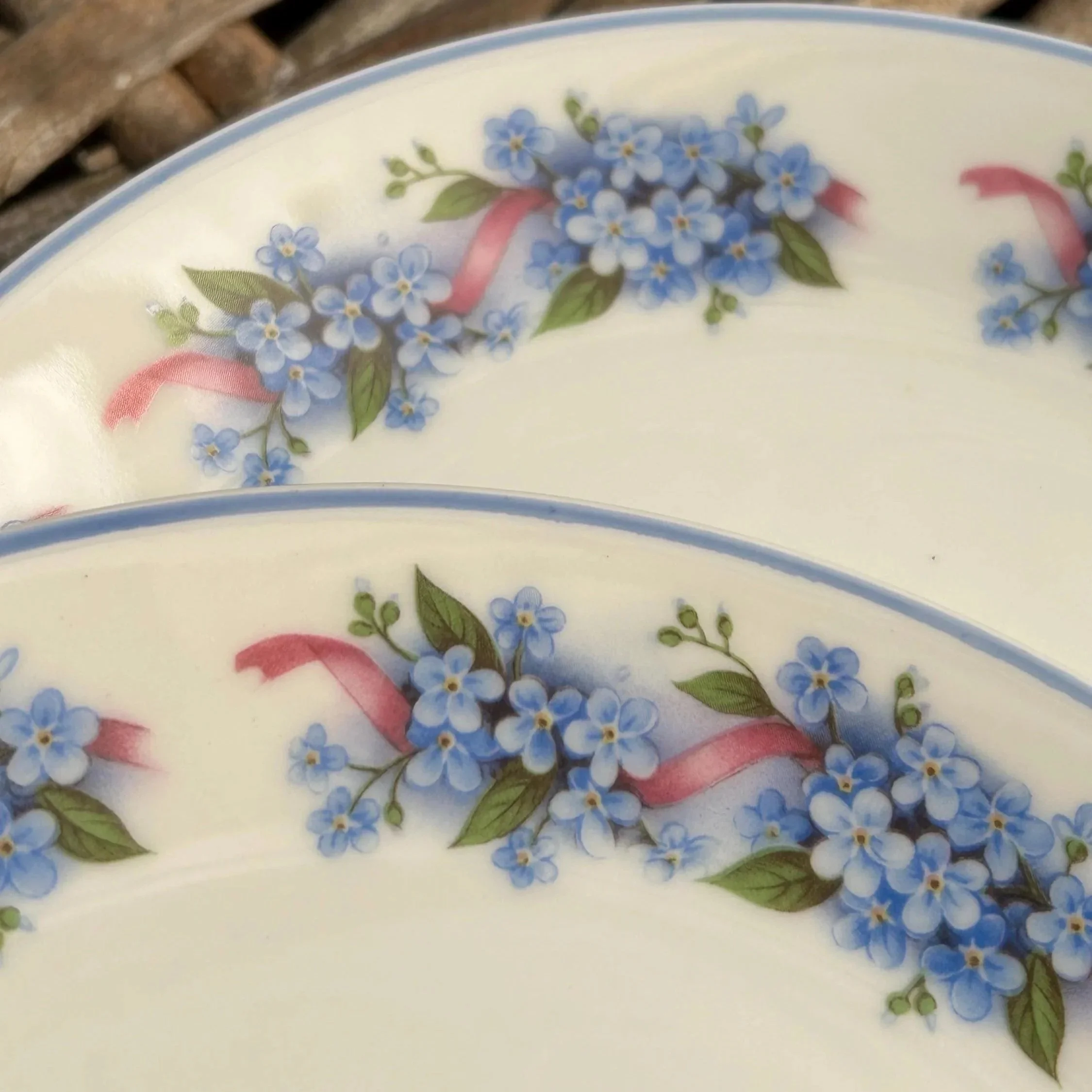 Paired close-up of two plates showing ribbon and flower detail