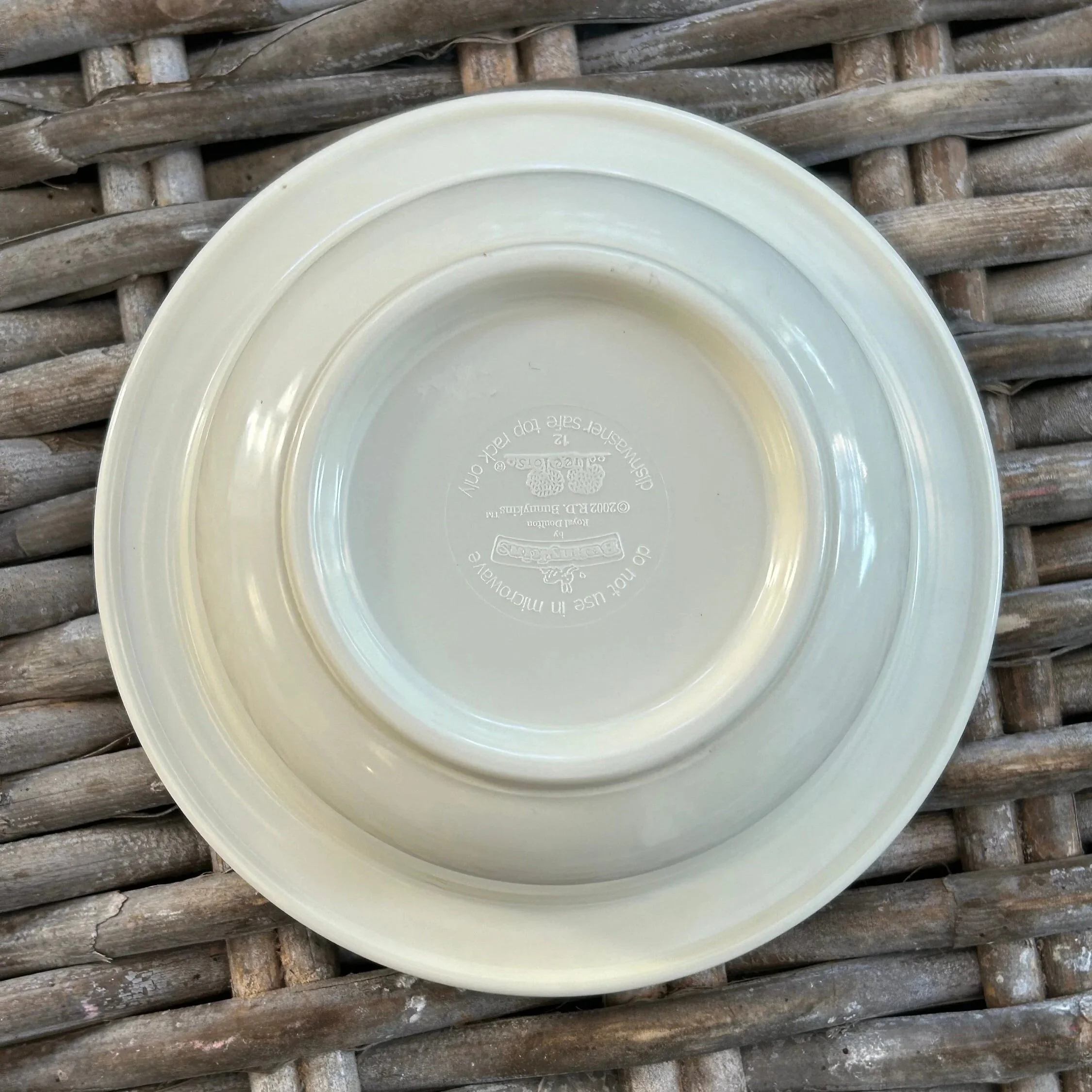 Underside of cream Bunnykins melamine bowl showing circular footed base and moulded maker’s details