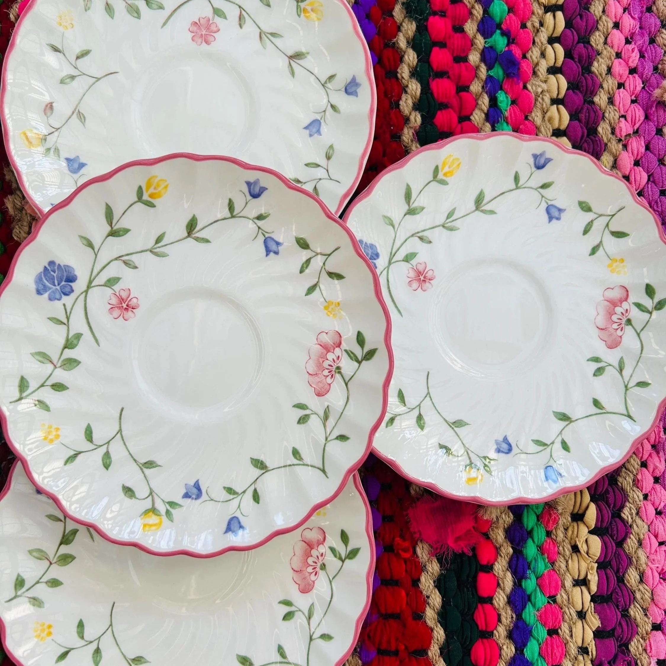 Full set of Johnson Bros Summer Chintz saucers arranged on colourful background
