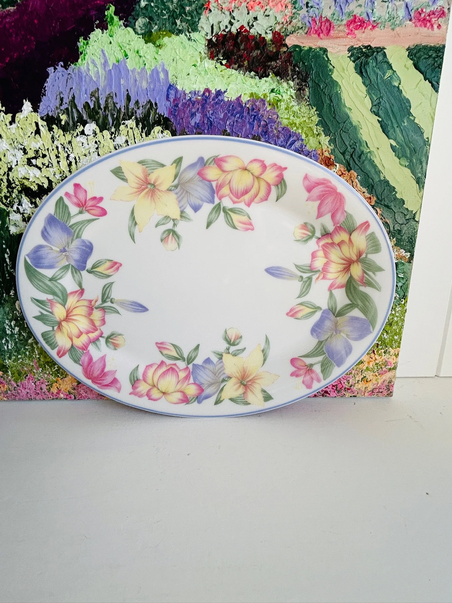 Royal Doulton Blooms oval serving platter displayed upright, showing the full pastel floral border with yellow, pink, and purple flowers on fine white china