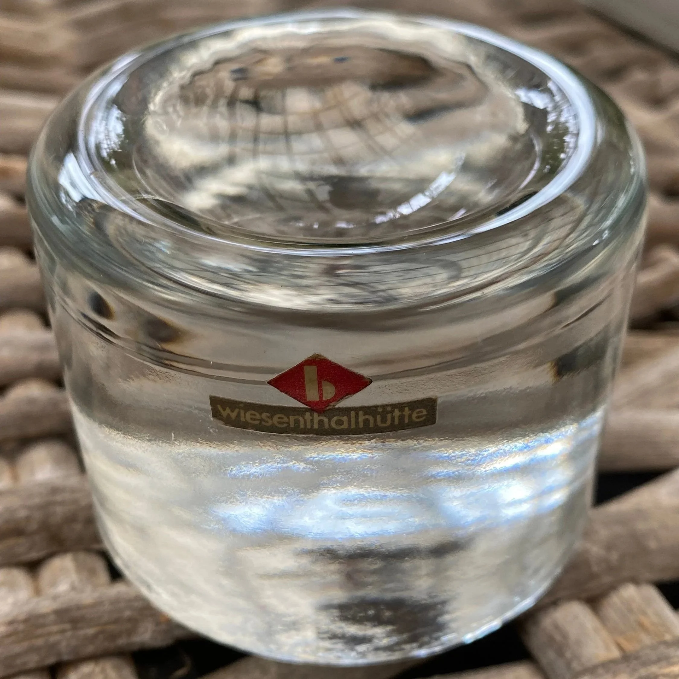 Angled top view of the vintage glass holder showing its rounded form and original label