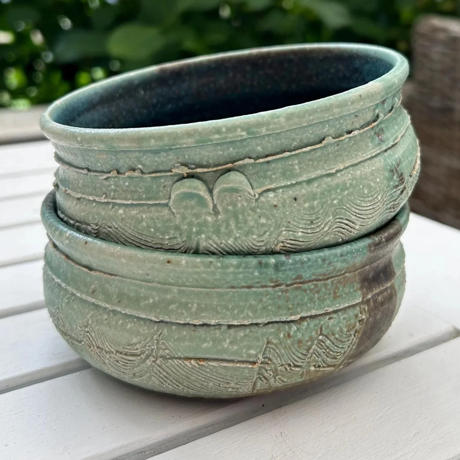Vertical stack of both bowls showing outer detail and raw clay accents