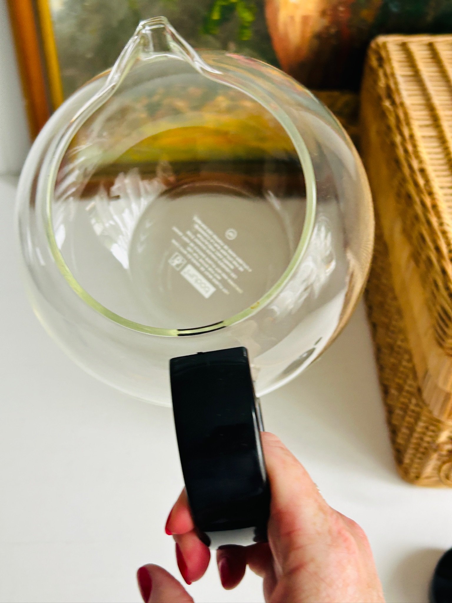 Top-down view into the glass teapot, showing the rounded body, black handle, and printed Bodum mark on the base.