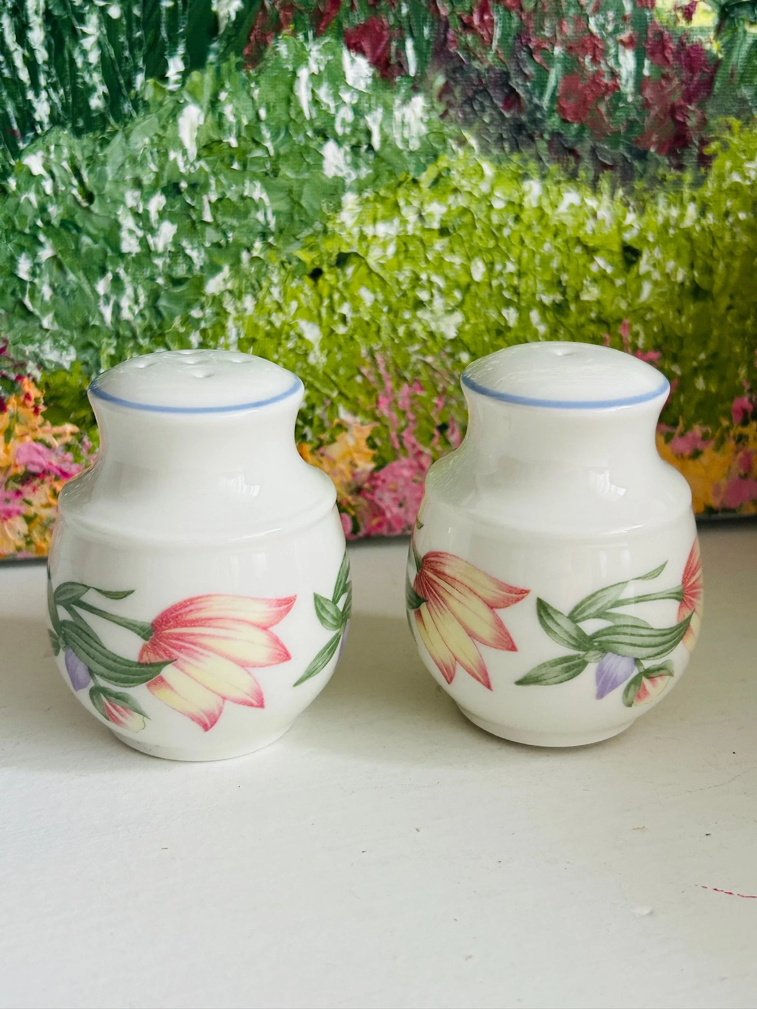 Pair of shakers standing together against a green painted background, showing the matching set in full