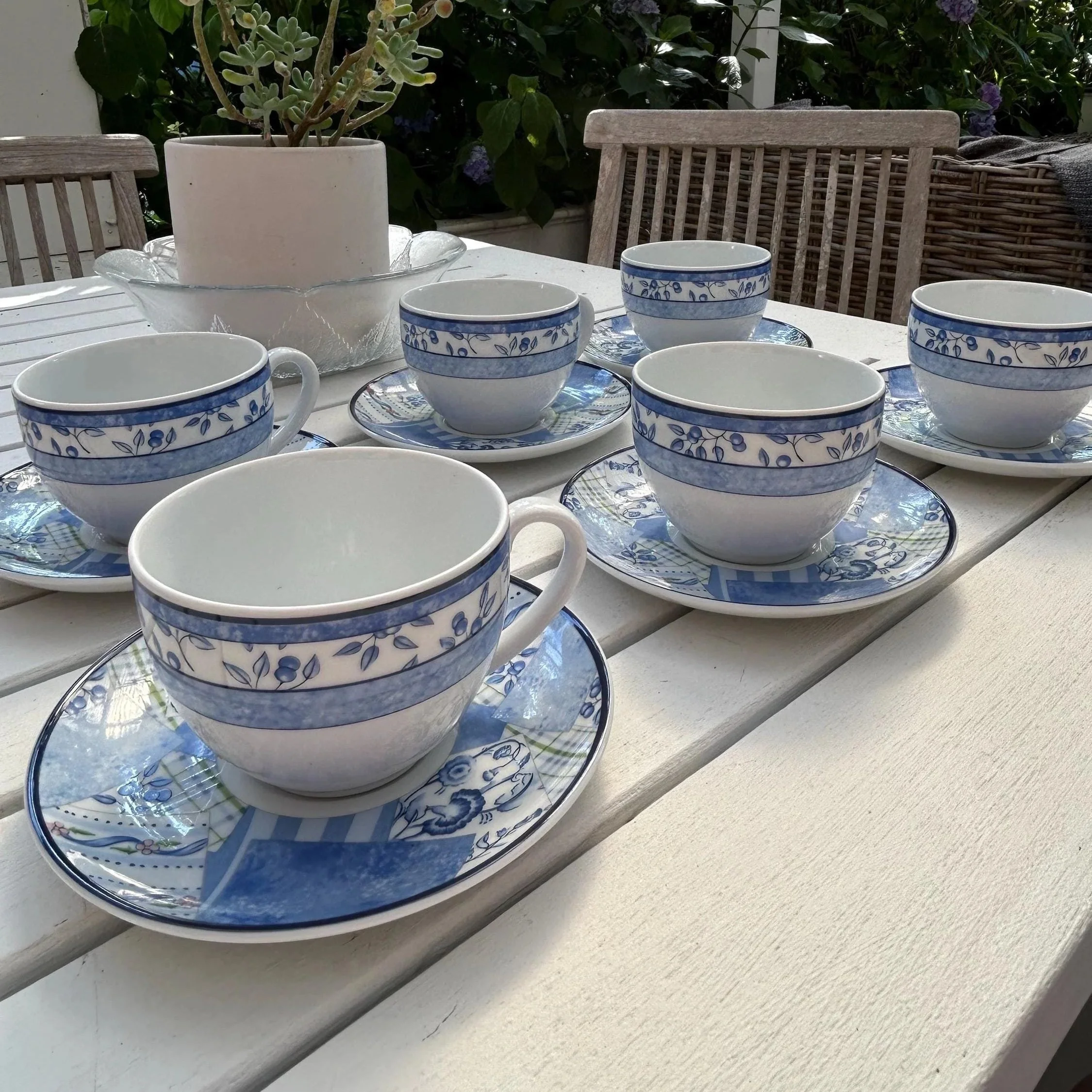 Set of six Wedgwood Home Indigo teacup and saucer duos arranged on a table outdoors