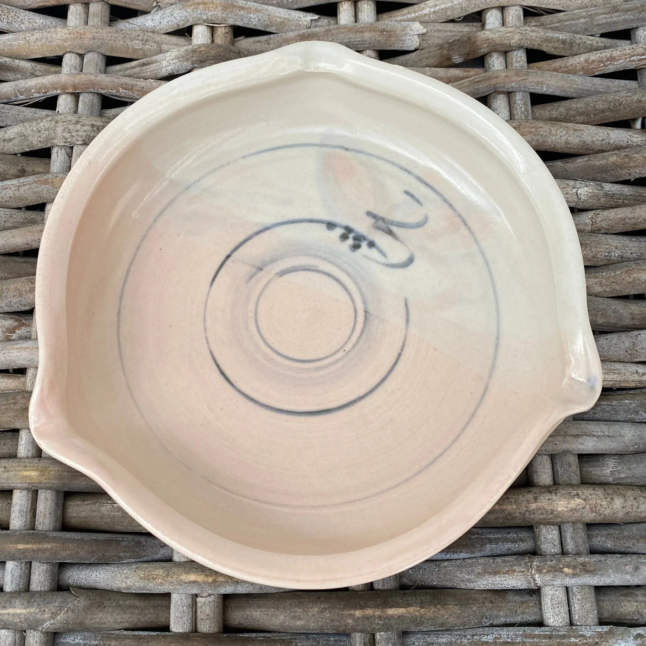 Overhead view of plate with decorative linework and signature