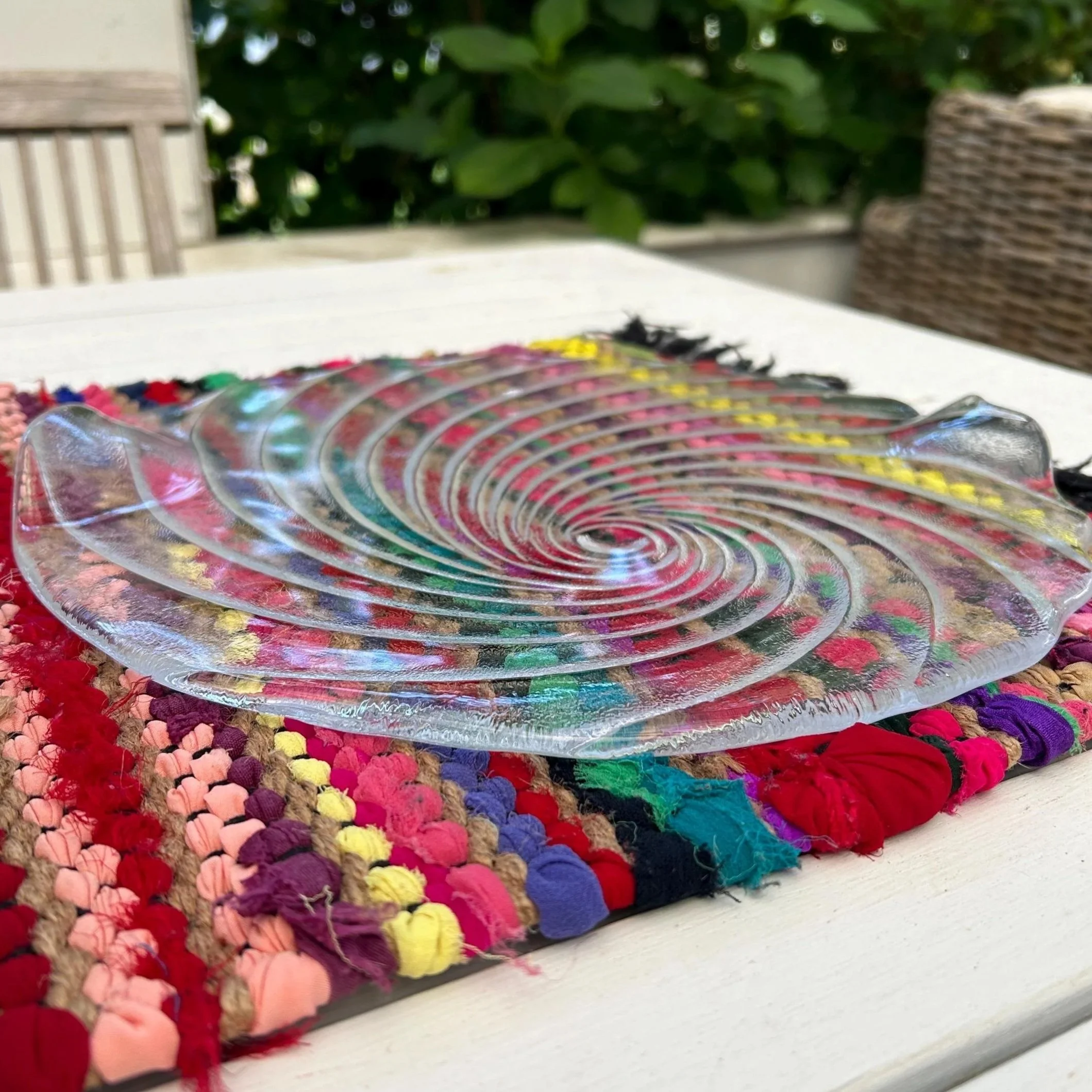 Platter resting on colourful woven mat showing full spiral pattern.